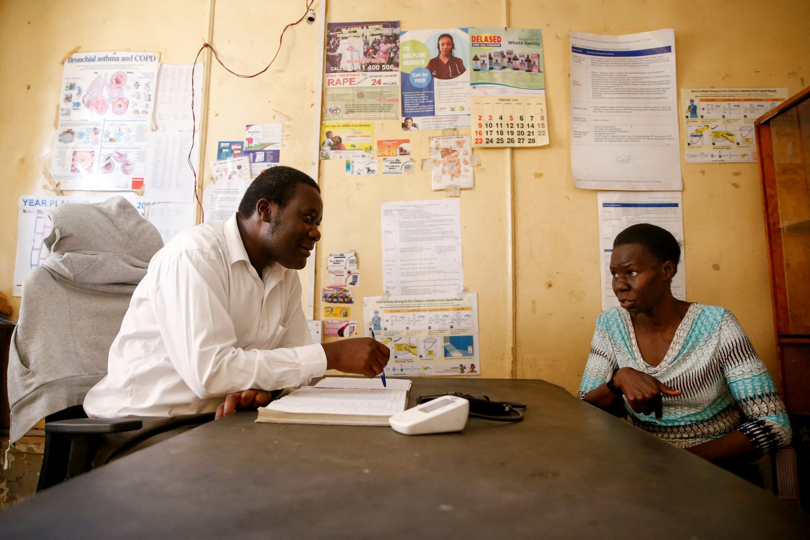 Alice Okwirry, 50, a widow living with HIV/AIDS, speaks with Tom Oketch, the administrator at the Ushirika Medical Clinic and Maternity Services, in Kibera district of Nairobi, Kenya February 28, 2025.