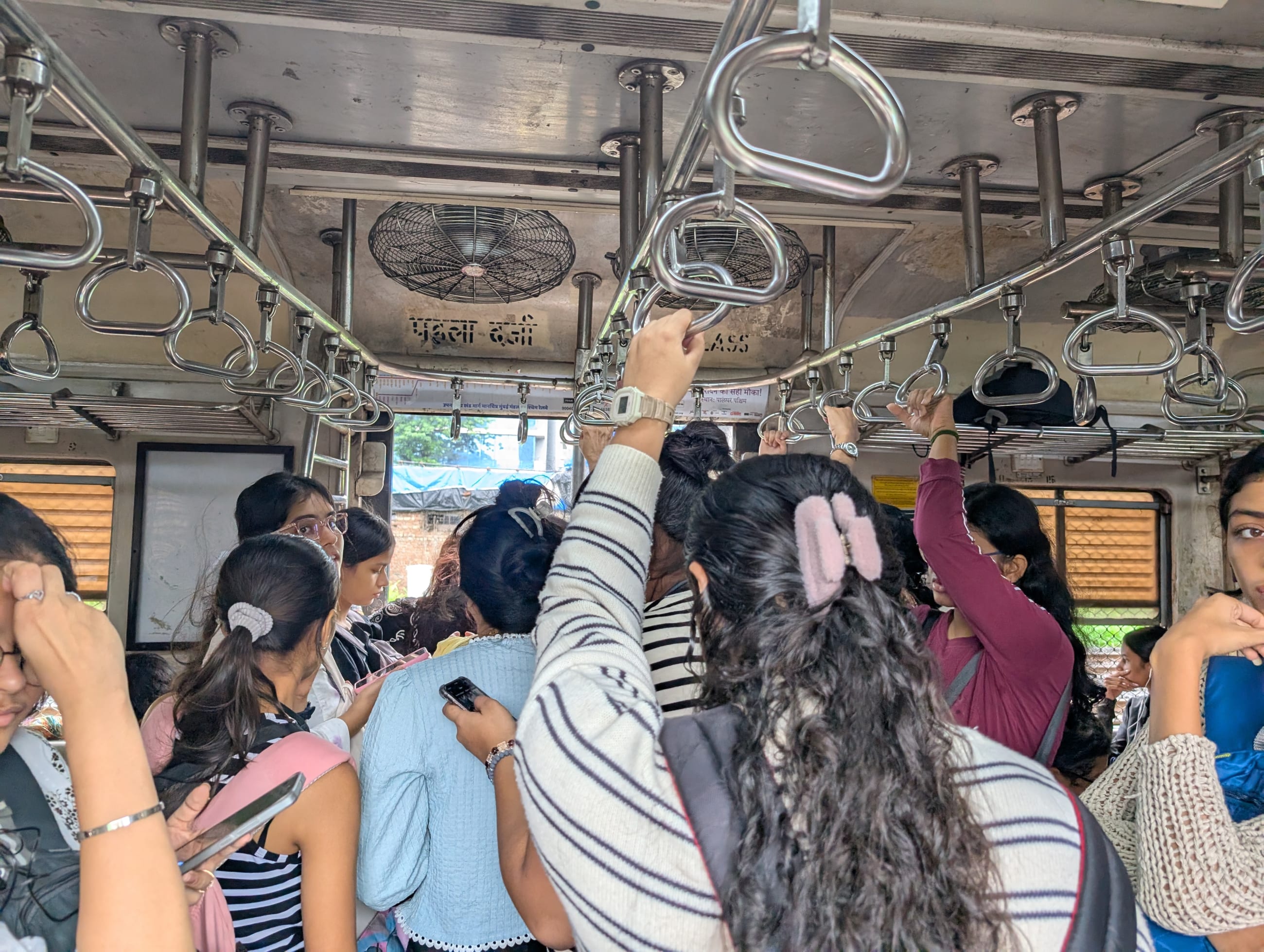 Commuters look to alight a ladies' compartment in a Mumbai train, on August 7, 2025.