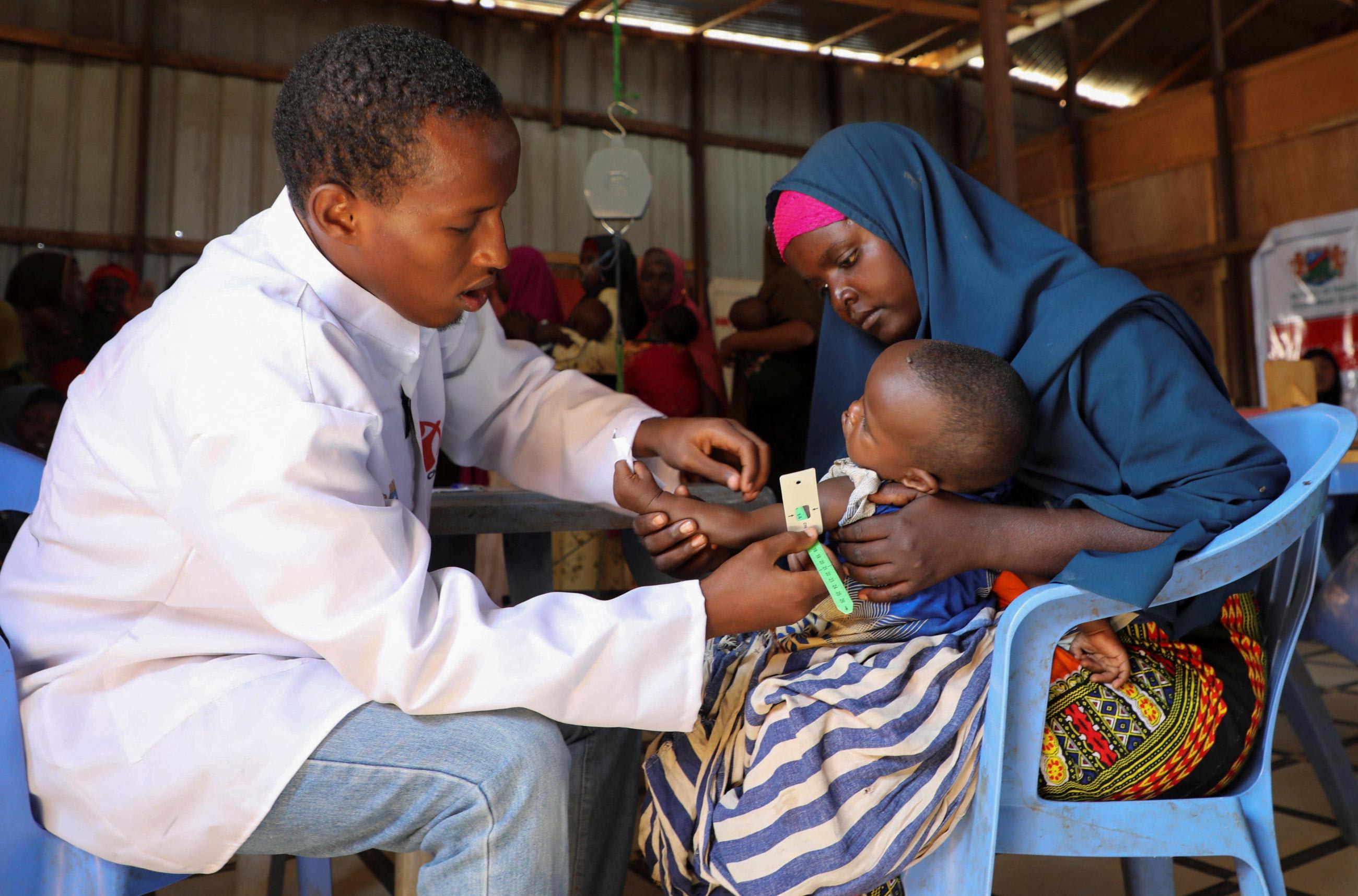 A nurse from Save the Children screens an internally displaced Somali child before vaccination, at the Tawakal 2 camp in Baidoa, Somalia, on June 24, 2025.