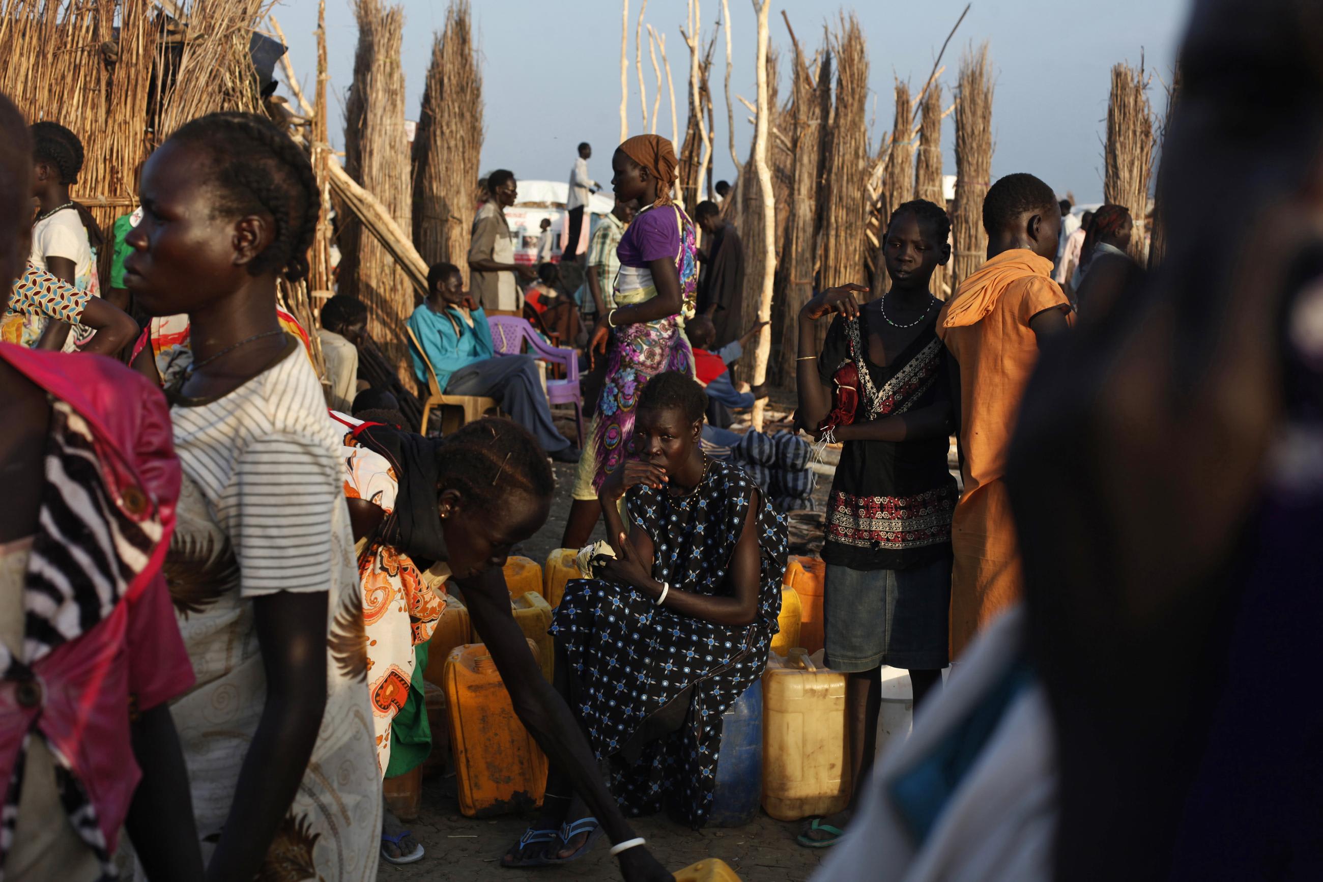 Women displaced by conflict wait to get clean water at the United Nations base.