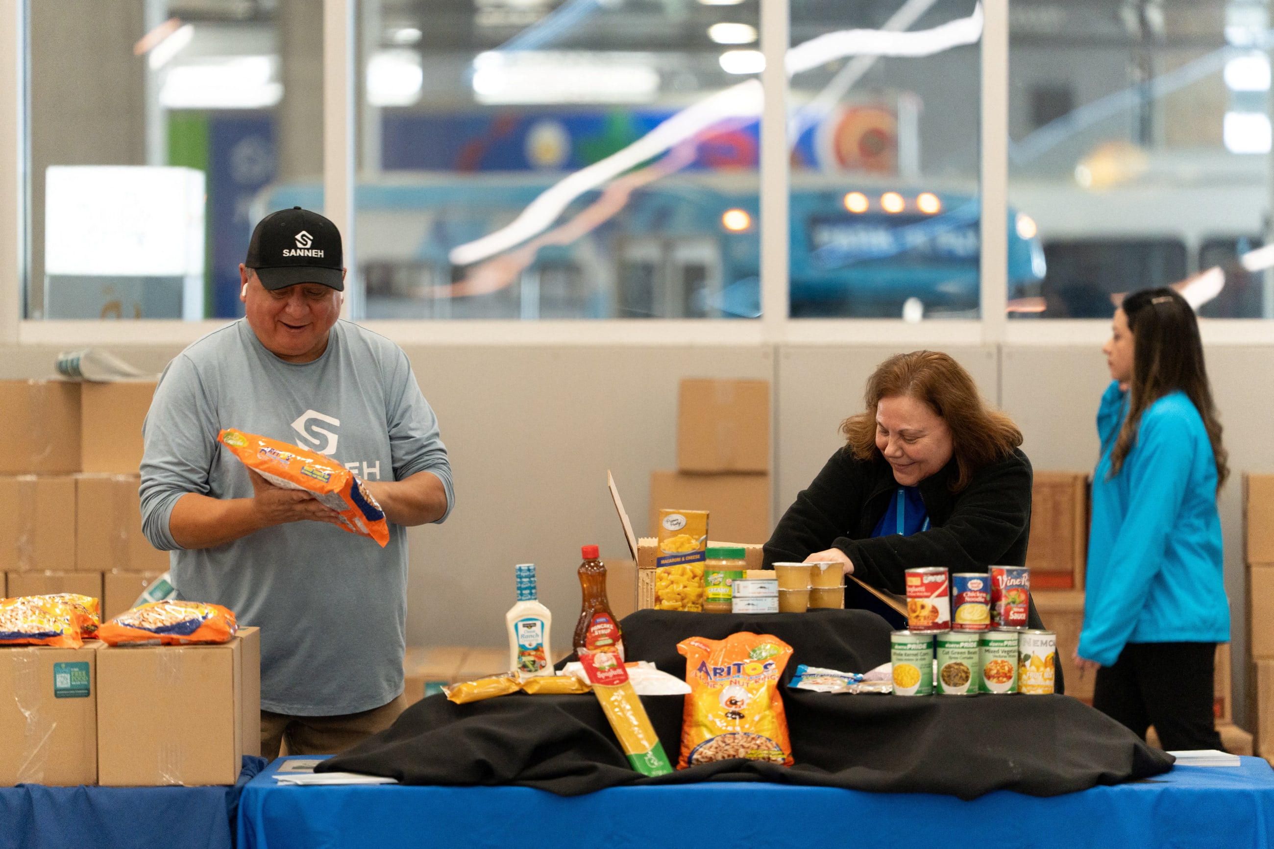 Volunteers with Second Harvest Heartland and the Sanneh Foundation prepare boxes of free food at a food pantry set up for Transportation Security Administration (TSA) staff and other federal workers affected by the government shutdown, at the Minneapolis–Saint Paul International Airport, in Minneapolis, on October 29, 2025.