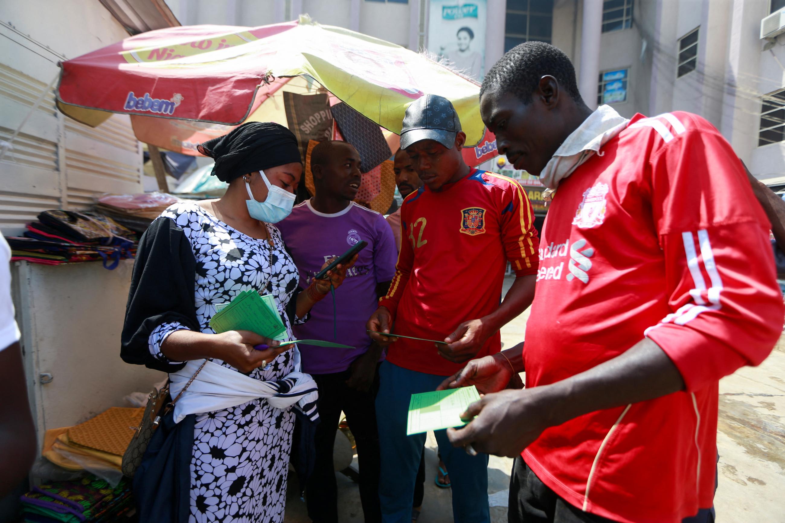 People are seen with their COVID-19 vaccination cards at the venue of a mass vaccination exercise.