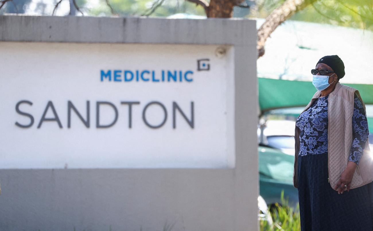 A woman stands at the entrance of Mediclinic.