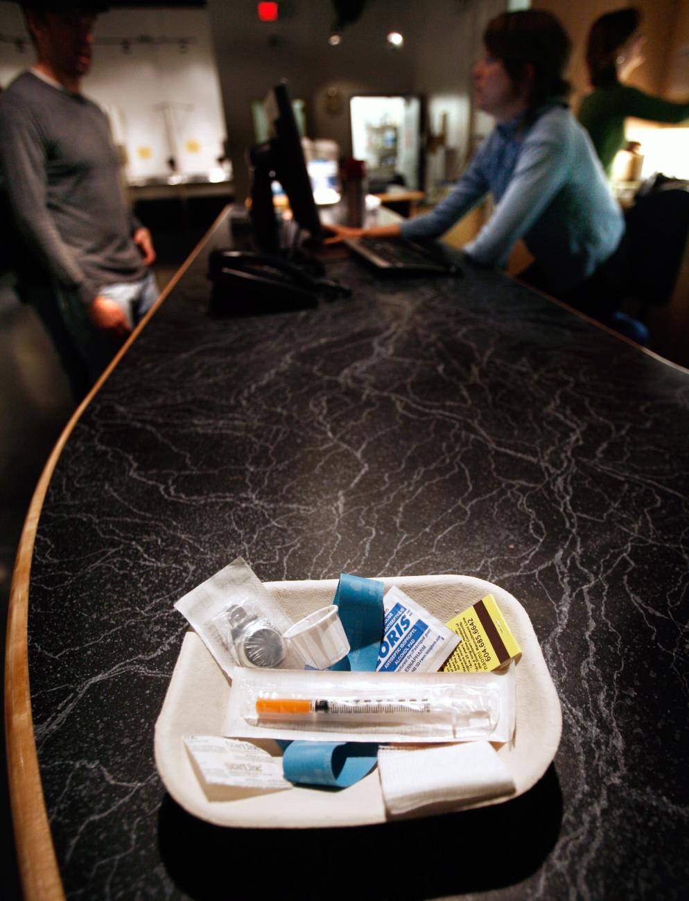 A small kit of supplies including syringes, bandaids and antiseptic pads waits to be used inside a safe injection site.
