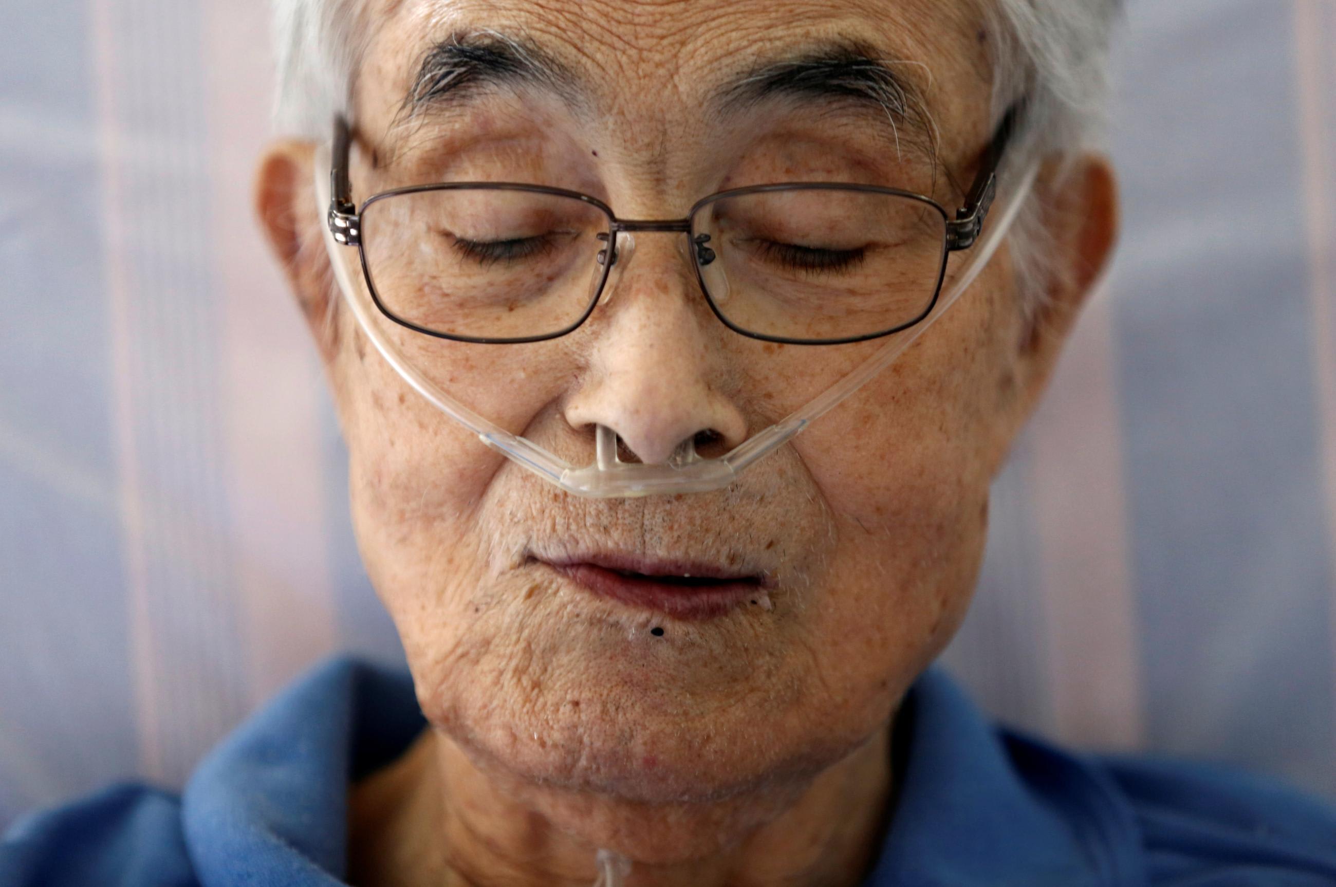 Katsuo Saito, 89, who has leukemia, uses an oxygen tube as he rests at his house, in Tokyo, Japan, on September 8, 2017.