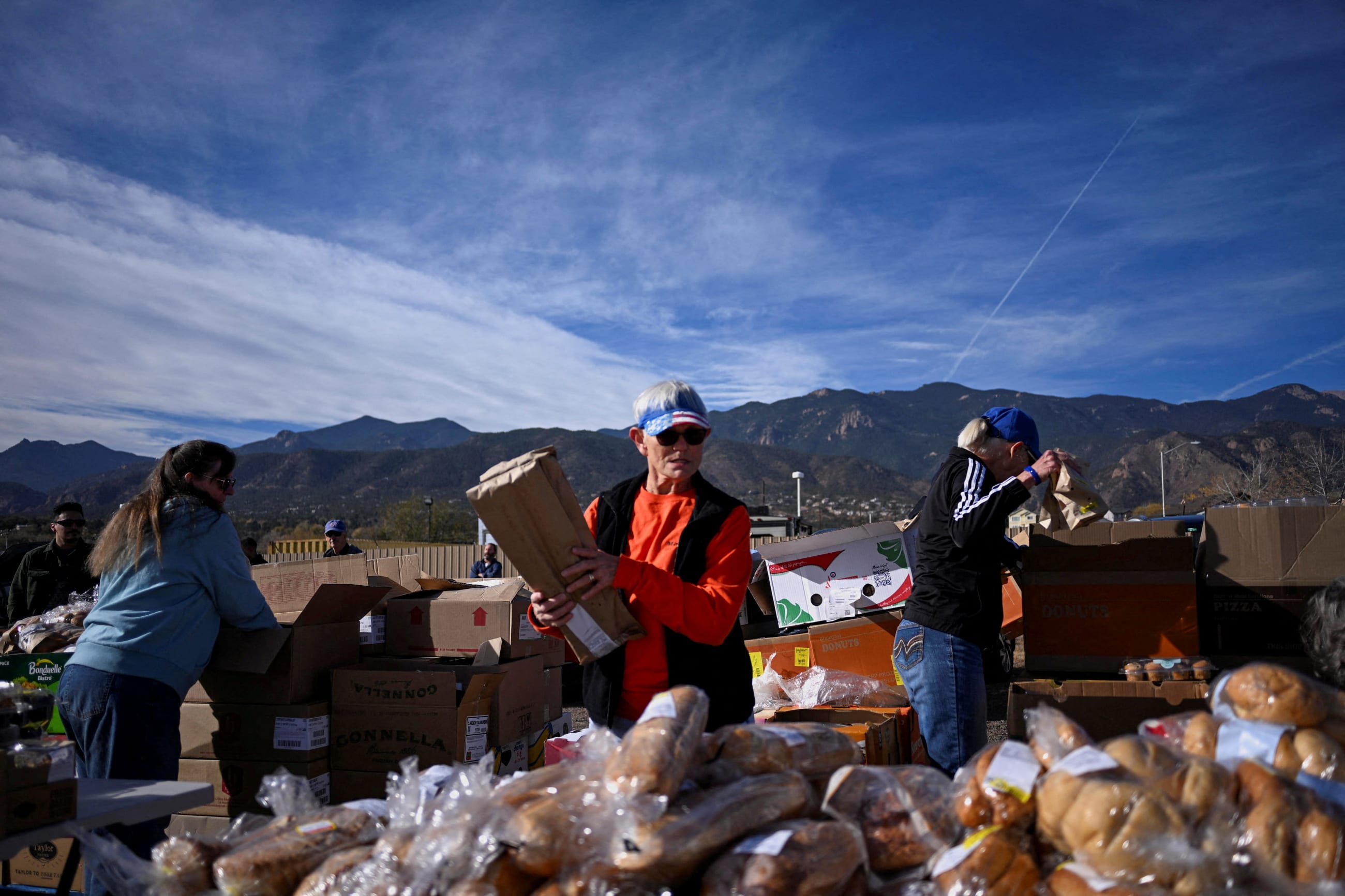 Volunteers prepare food for more than 100 cars in line at the Mt. Carmel Veterans Service Center food distribution site, in Colorado Springs, Colorado, on November 7, 2025.