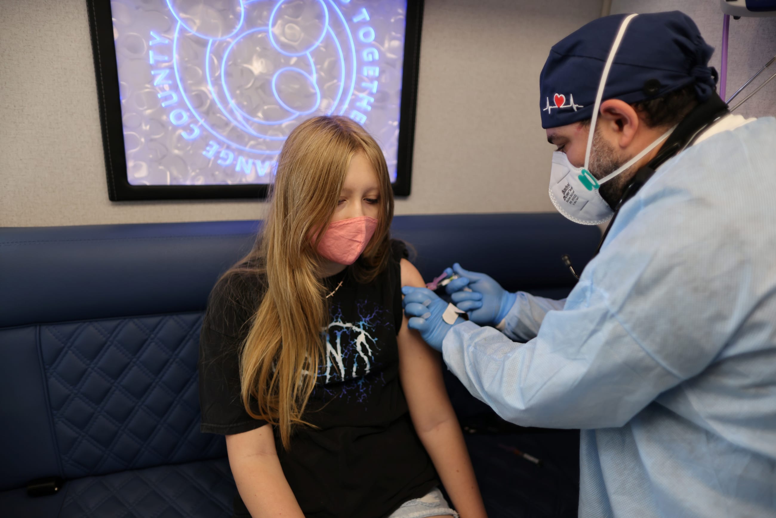 Parsia Jahandani gives Savannah, 12, vaccines against hepatitis, human papillomavirus (HPV), and meningitis at a back-to-school clinic, in Westminster, California, on August 19, 2021.