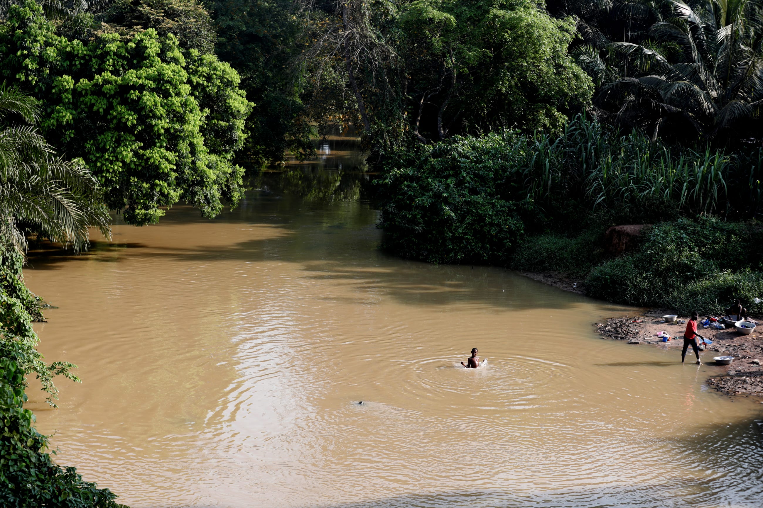 A boy swims in a river polluted by gold mining waste, in Nsuaem district, Ghana, on November 23, 2018.