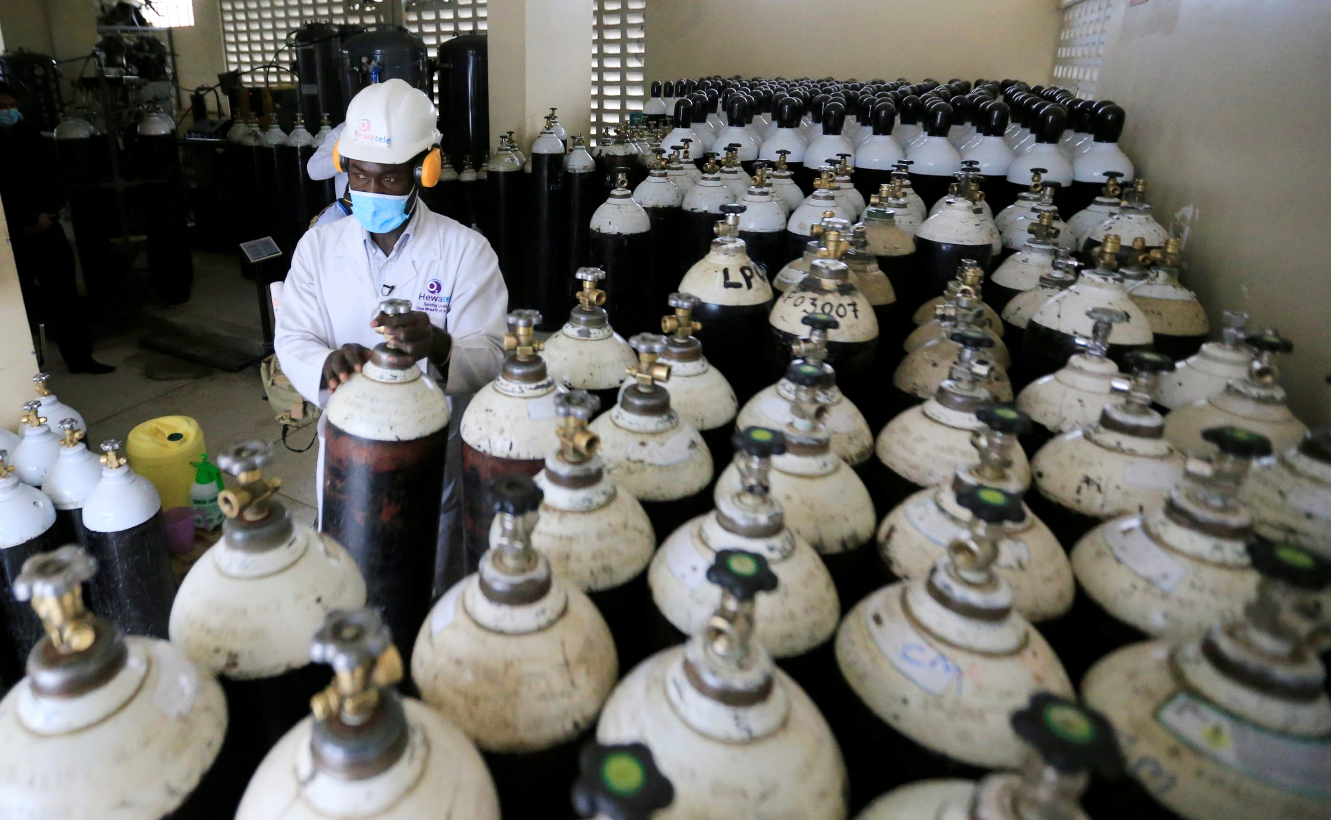Walter Otieno, plant operator at Hewatele, arranges empty oxygen medical cylinder tanks at the Hewatele oxygen plant, in Nairobi, Kenya, on August 3, 2021.