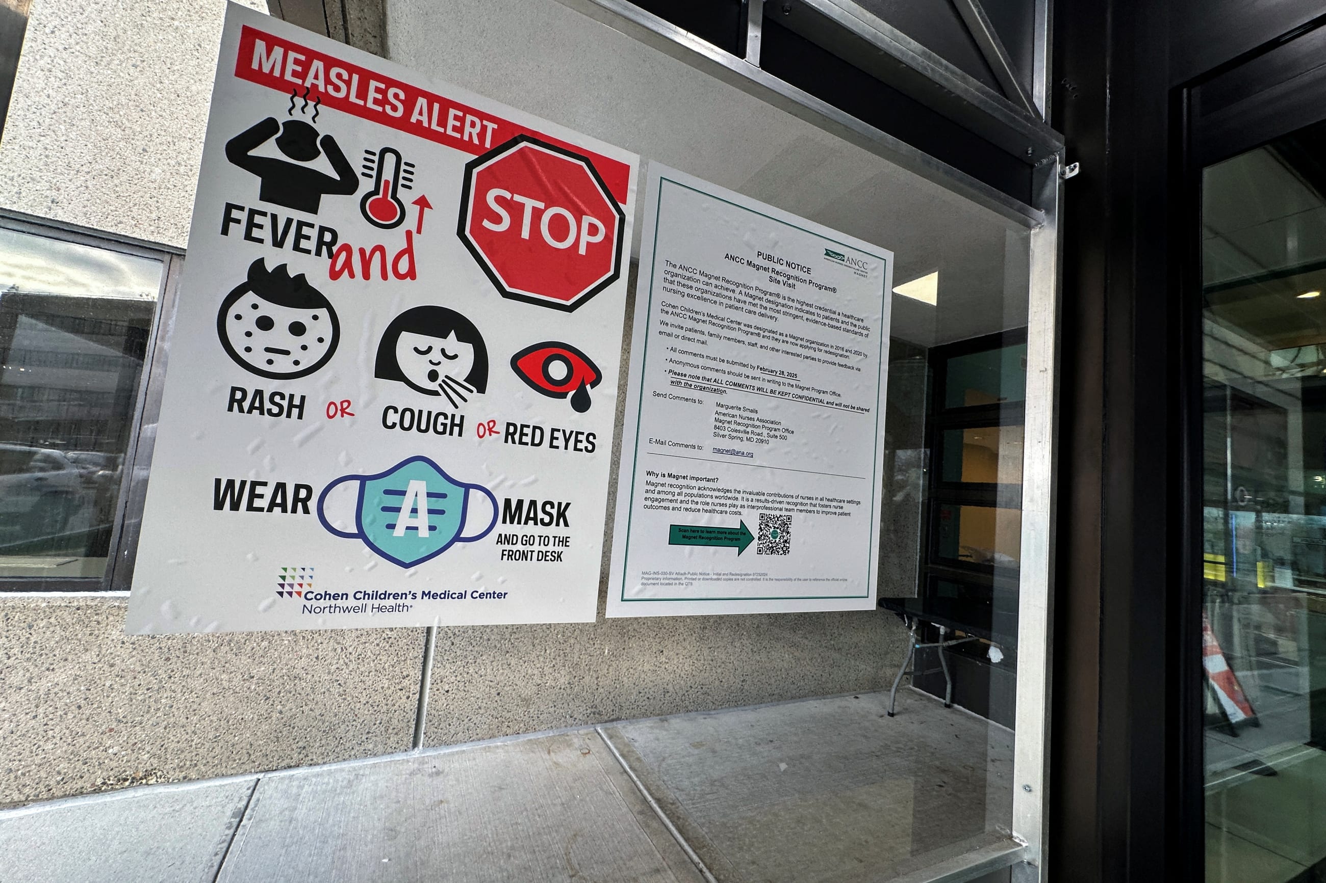 A measles alert sign hangs outside the entrance to the Cohen Children's Medical Center, in New Hyde Park, New York, on March 14, 2025.
