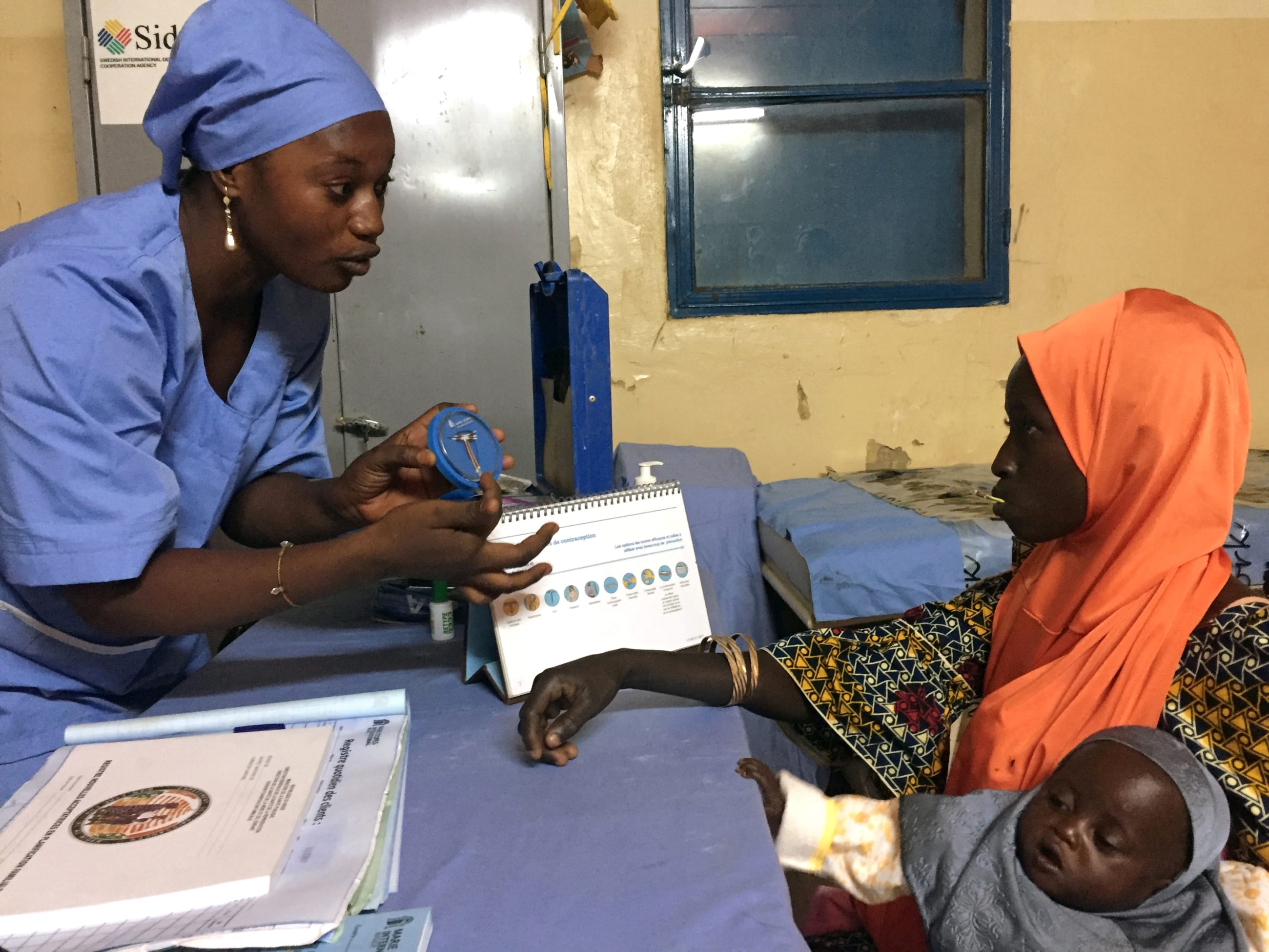 A nurse explains to a young mother how a contraceptive implant works, in the village of Libore, southeast of Niamey, Niger, on November 2, 2017.