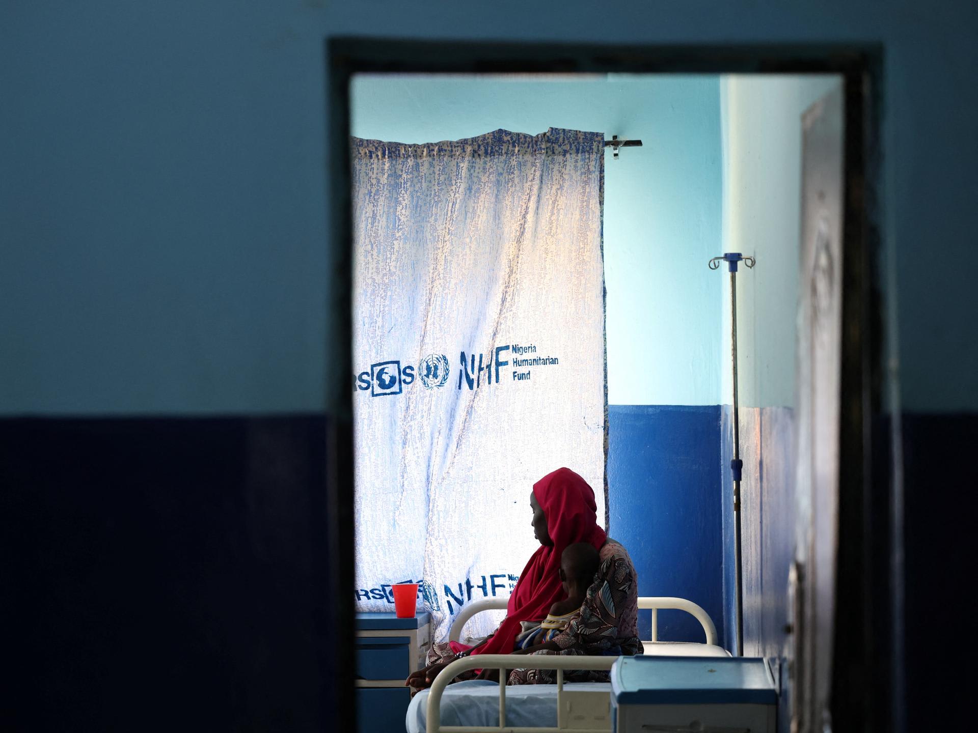A woman and her child, who is suffering from malnourishment, wait for care at Dikwa Primary Health Center's emergency ward, following the withdrawal of USAID support, in Dikwa, Borno State, Nigeria, on August 27, 2025.