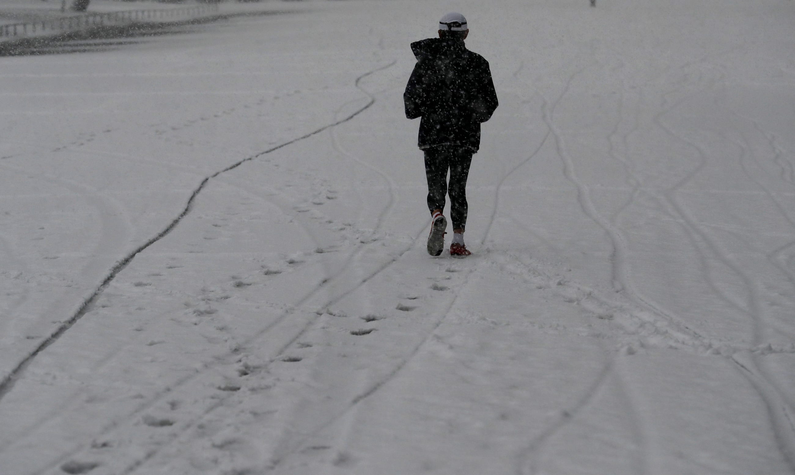 A man jogs in the heavy snow at the Imperial Palace in Tokyo, Japan January 22, 2018