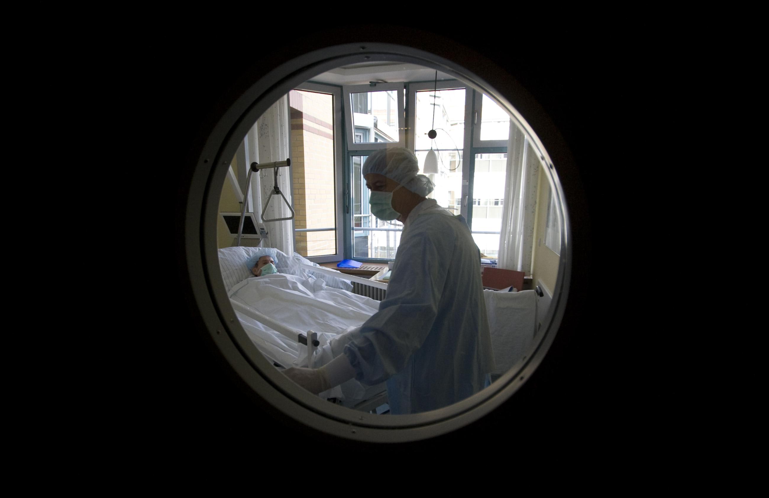 A patient with MRSA (Methicillin-resistant Staphylococcus aureus) is pictured through the window of a security door, before he is transferred from his isolation room to the operating theater, at the Unfallkrankenhaus Berlin hospital in Berlin, February 29, 2008.