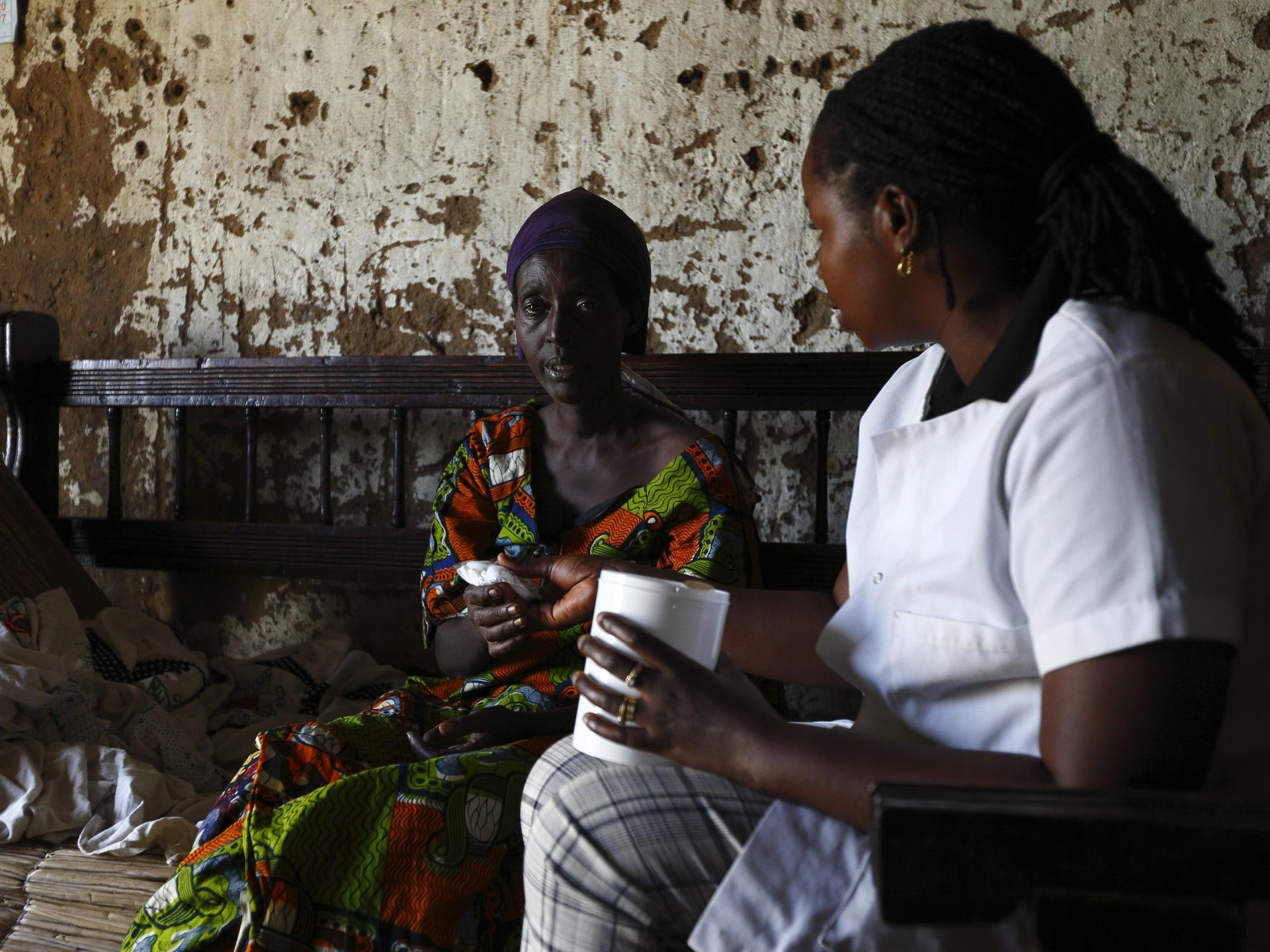 A Service Yezu Mwiza nurse hands medication to an HIV patient, who is also suffering from malaria, at her home, in Gatumba, Burundi, on April 19, 2013.