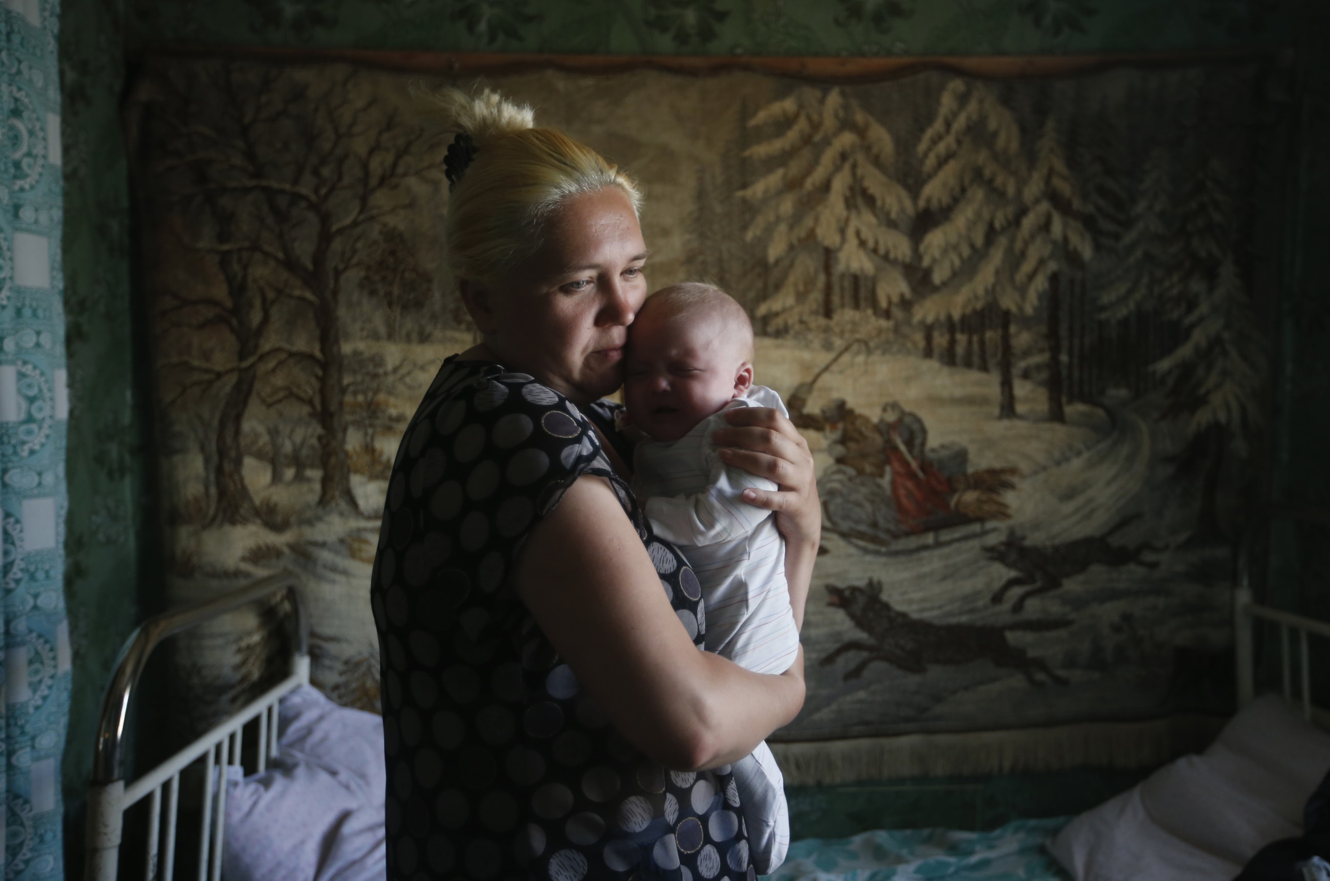 A mother and child who have fled from fighting in Slaviansk, stand in their temporary accommodation, in the town of Nizhnaya Krinka, in eastern Ukraine, on June 4, 2014.