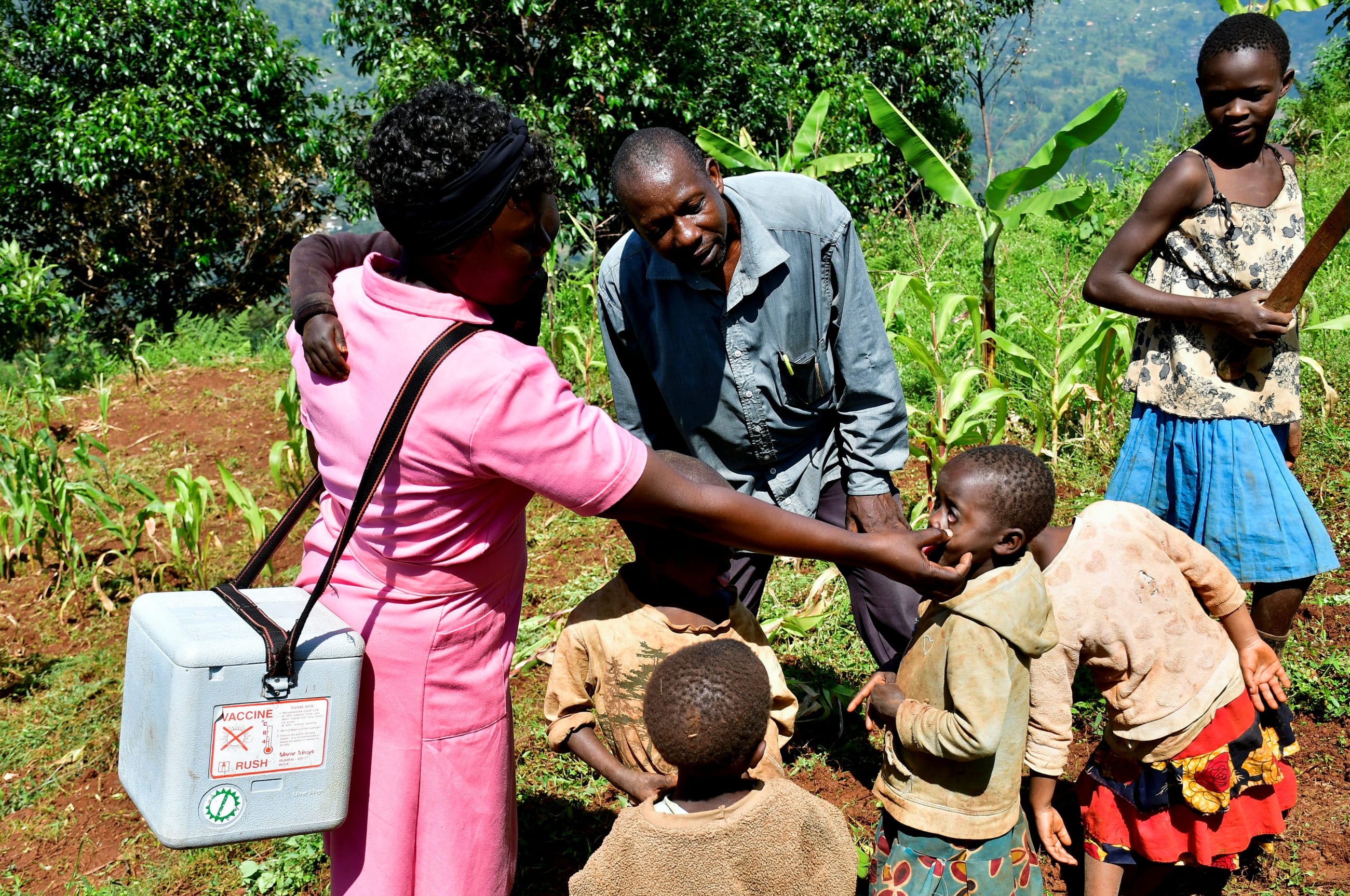 Ugandan nurse Agnes Nambozo, carries a box of medical supplies as she meets a family during her community immunization outreach program, in Mushelusi village, in Bulambuli district, Uganda, on September 10, 2025.
