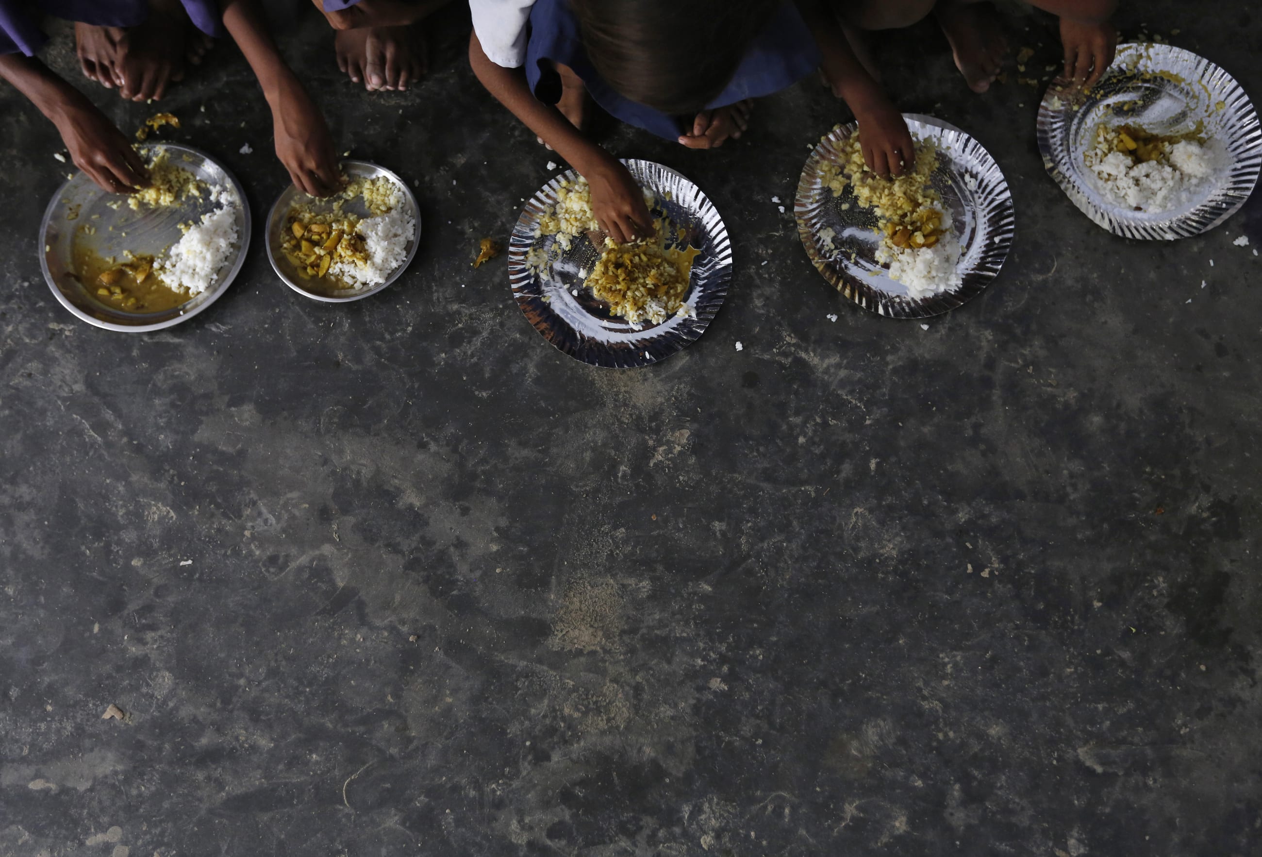 School children eat their free mid-day meal, distributed by a government-run primary school in Brahimpur village, in Chapra district, India, on July 19, 2013.
