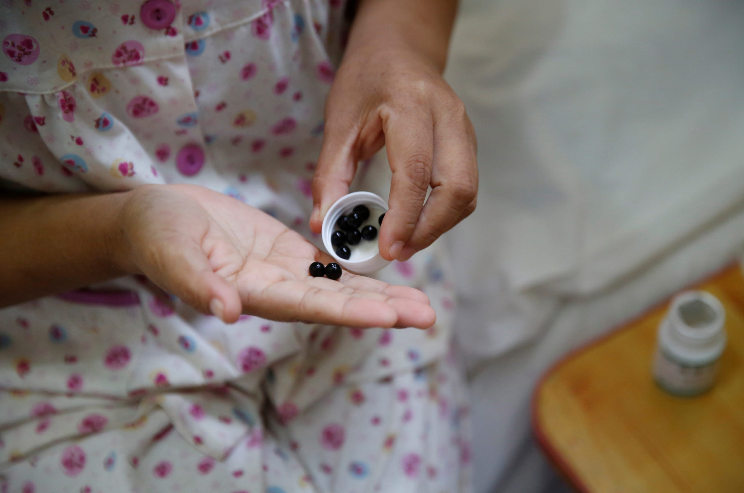 A woman suffering from cervical cancer takes her medicine at the accommodation where some patients and their family members stay while seeking medical treatments, in Beijing, China, on June 23, 2016.