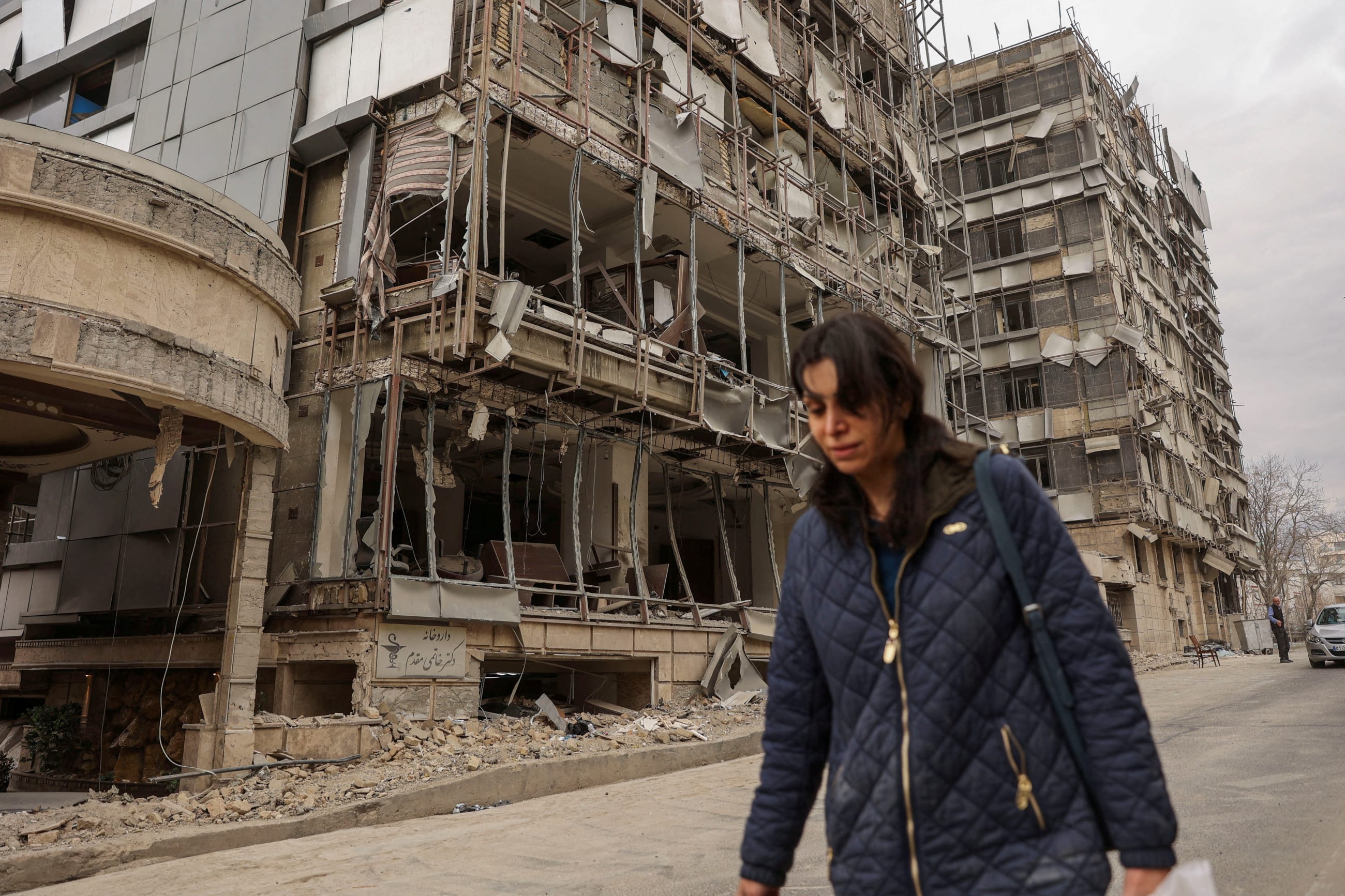 A woman walks on the street following an Israeli and U.S. strike on Gandhi Hotel Hospital, in Tehran, Iran, on March 2, 2026.