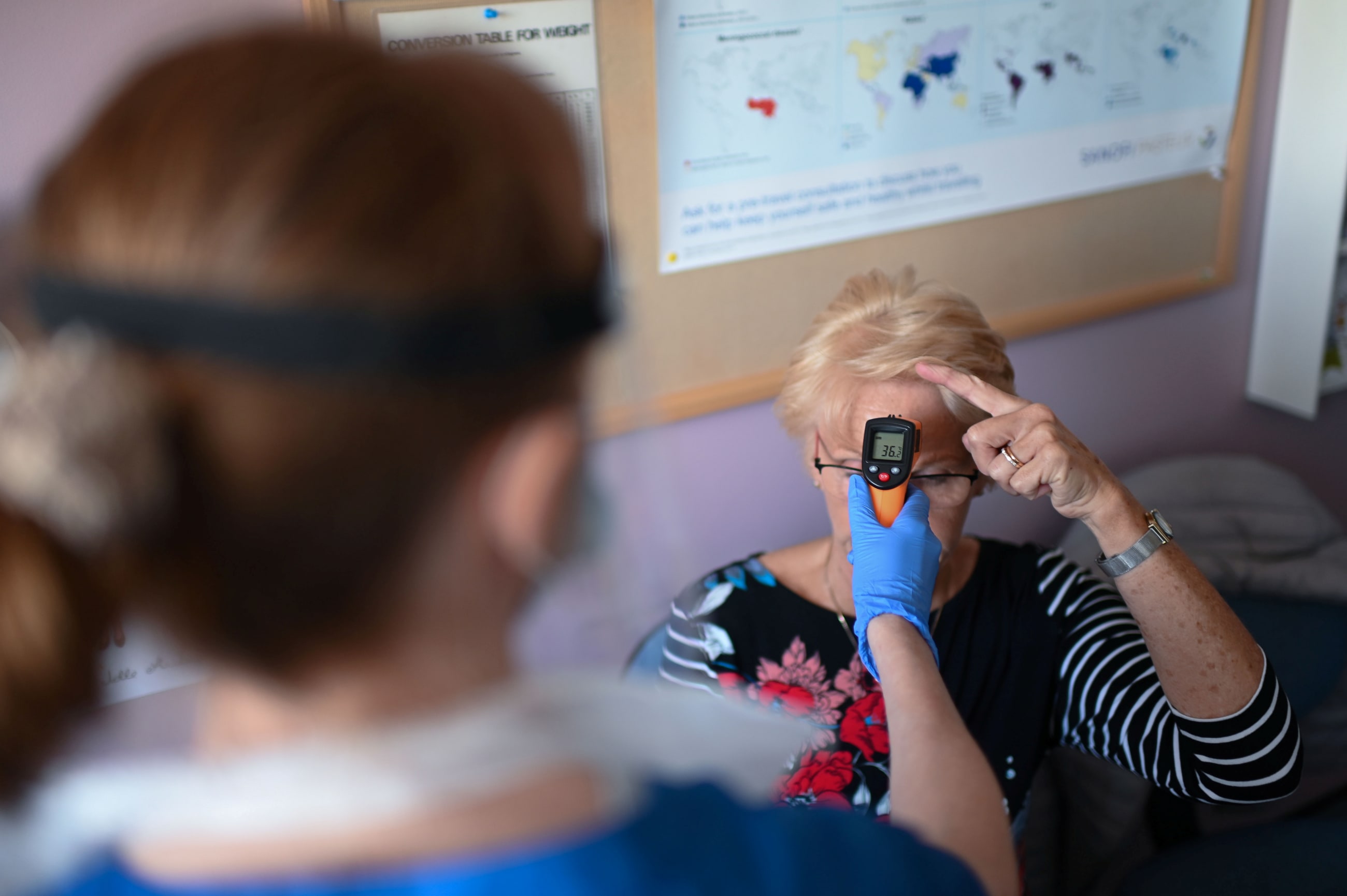 A nurse uses a non-contact infrared thermometer to measure the temperature a patient at Freshney Green Primary Care Center, in Grimsby, Britain, on June 9, 2020.