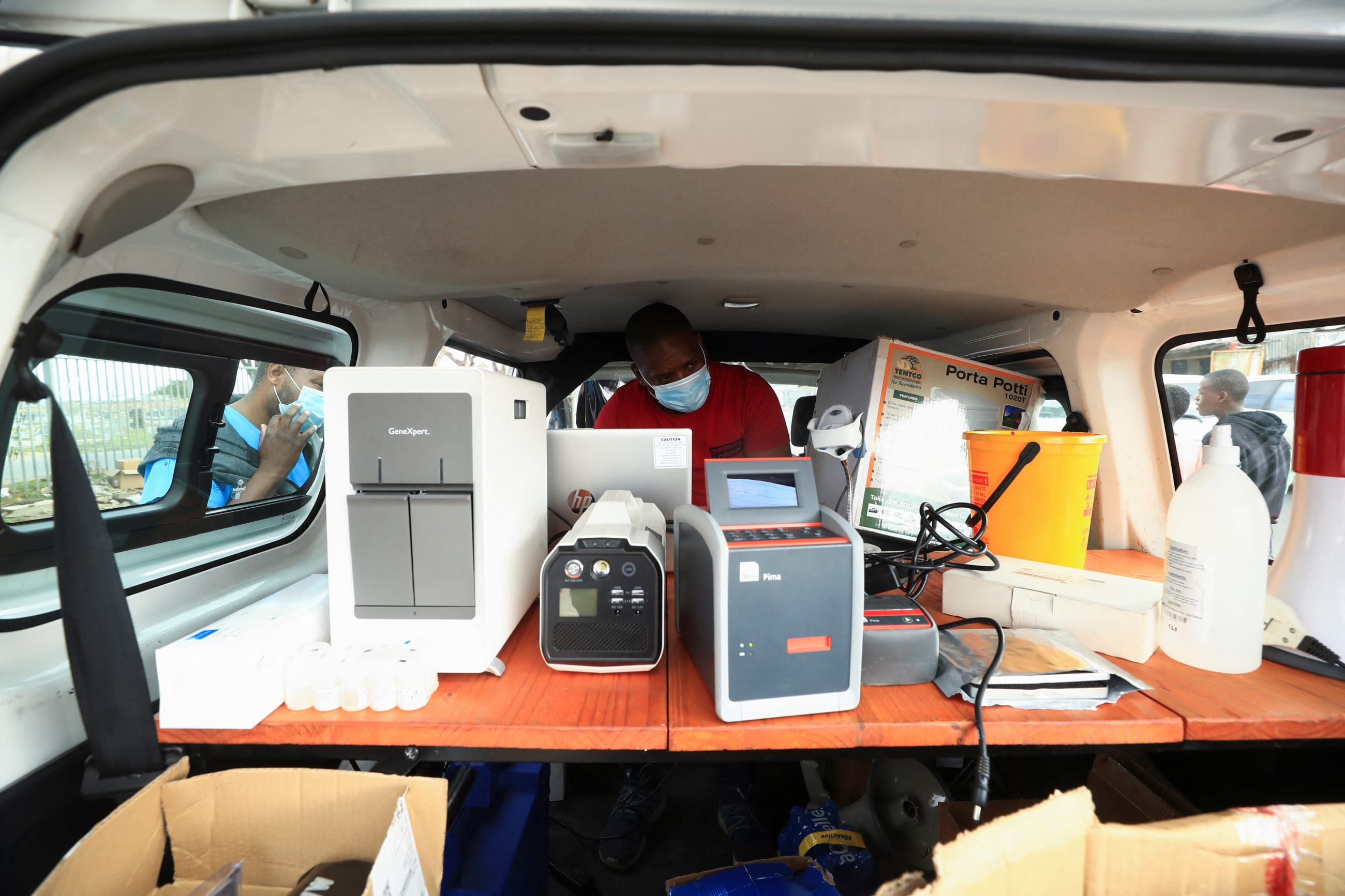 Healthcare workers monitor machines analysing tuberculosis samples at a mobile clinic, in Gugulethu township near Cape Town, South Africa, on March 26, 2021.