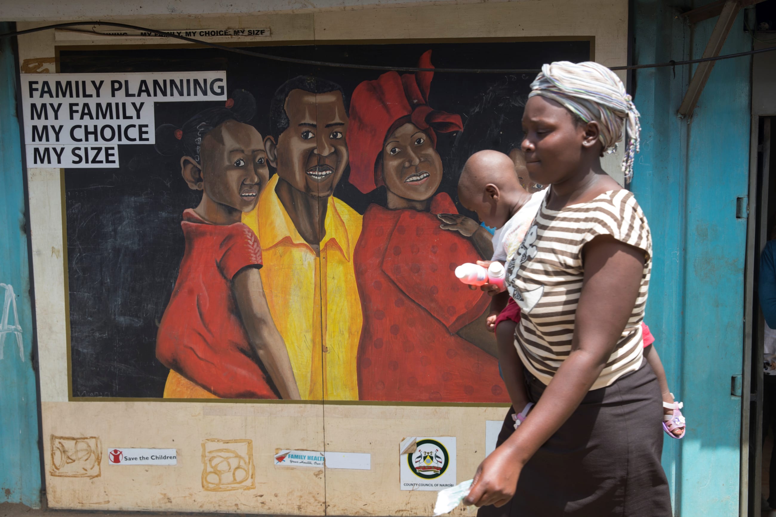 A woman walks past a mural at a family health options clinic, in Nairobi, Kenya, on May 16, 2017.