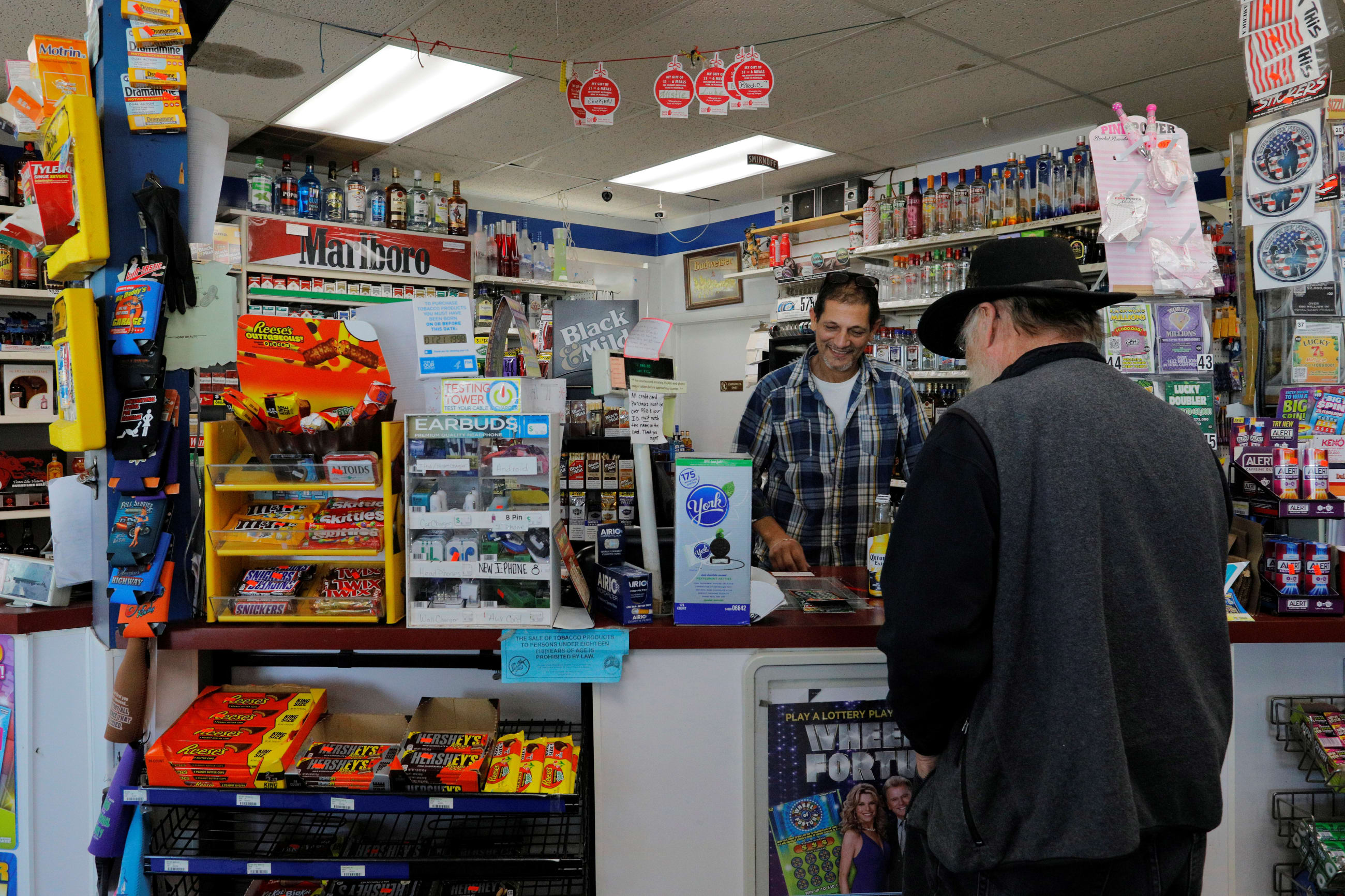 Khirfan's Super K convenience store owner Brad Khirfan, attends to a customer, in Flint, Michigan, on October 9, 2019.