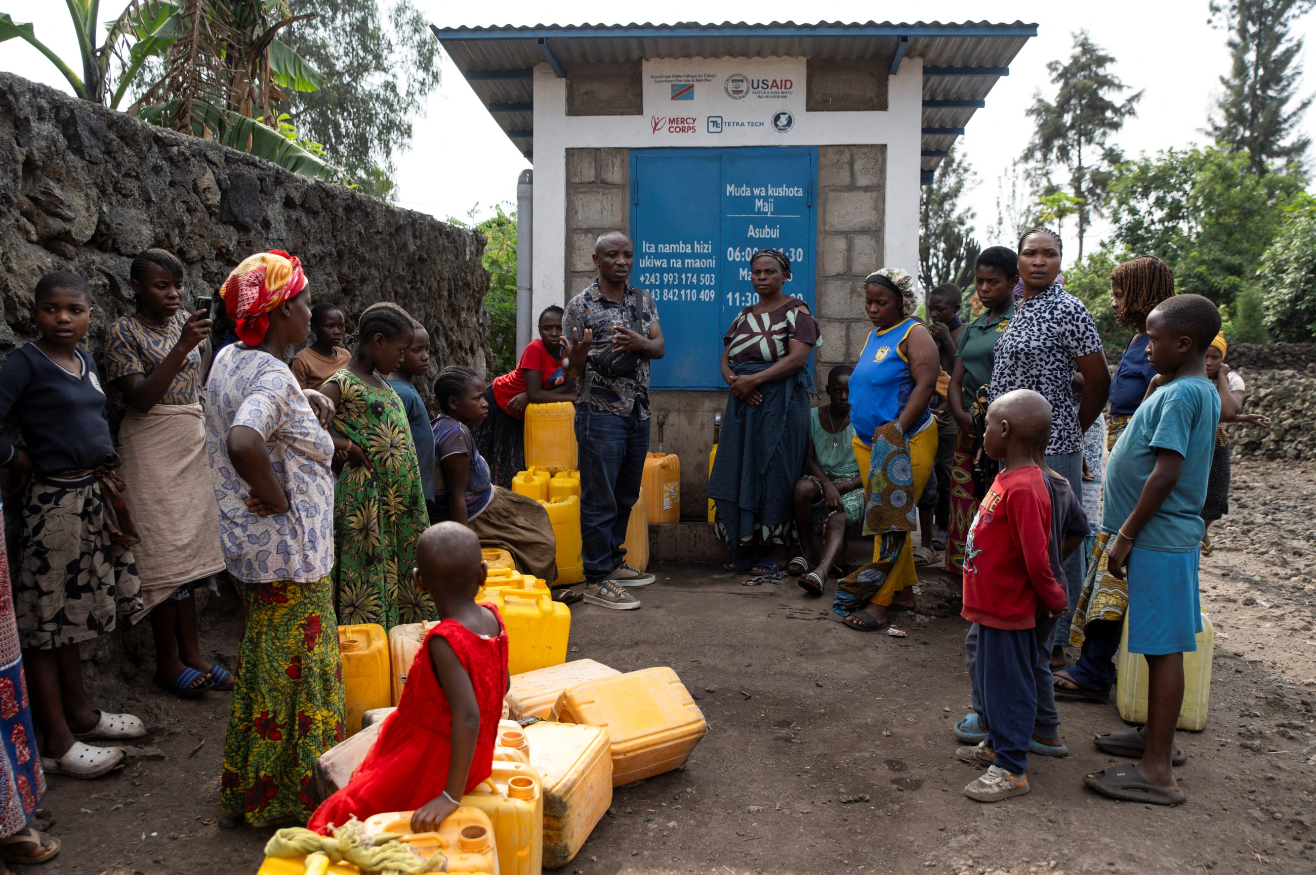 Etienne Mutaulwa talks to the residents who came to draw water from the half-operational standpipe, where incomplete water connections caused by USAID funding cuts have led to ongoing water shortages, in Goma, Democratic Republic of Congo, on June 16, 2025.