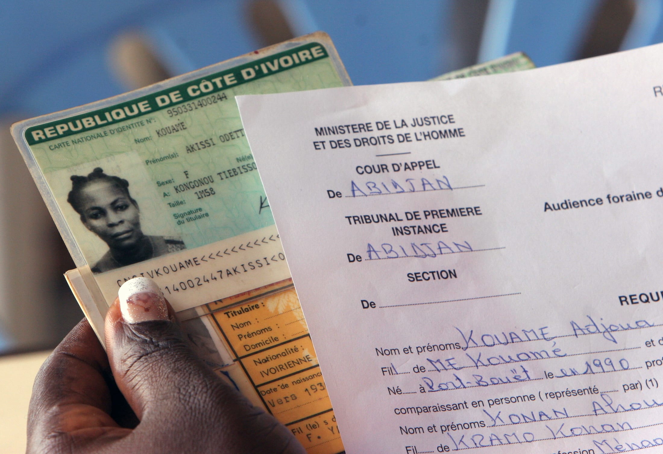 A town hall worker examines identity documents of a witness who has come to testify to the identity of an individual making an application for a birth certificate, in Abidjan, May 18, 2006. Ivory Coast citizens who remain without identity papers must urgently be given documents if the war-scarred West African state is to hold [elections] due by October, the main opposition leader said on Thursday.