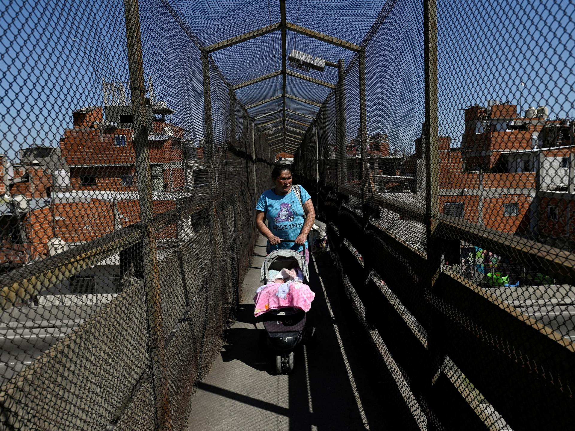 A woman pushes a baby stroller, in Villa Soldati, Argentina, on September 16, 2024.