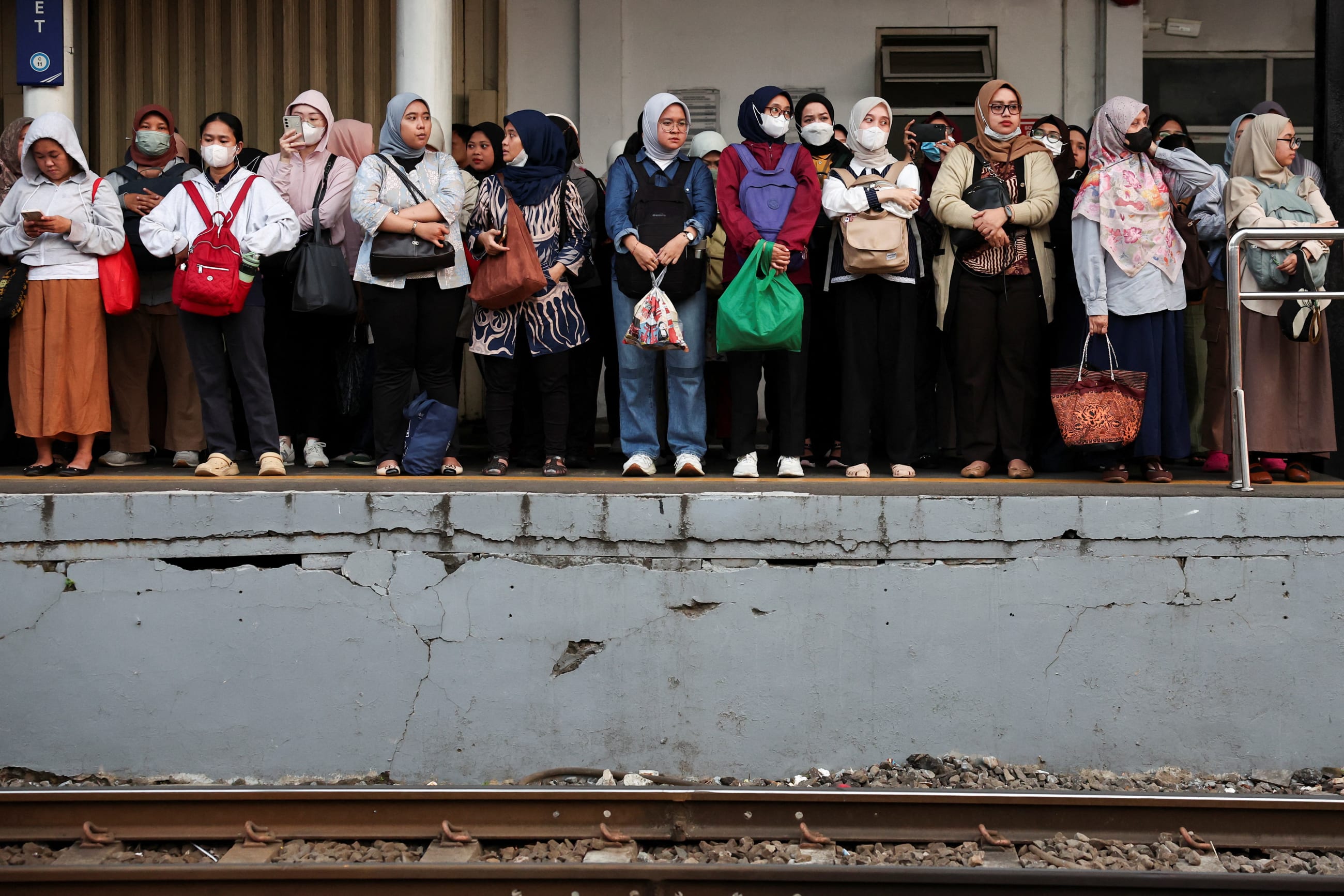 Passengers, mostly women, stand on the platform as they wait for a commuter train during afternoon rush hour, in Jakarta, Indonesia, on April 29, 2026.