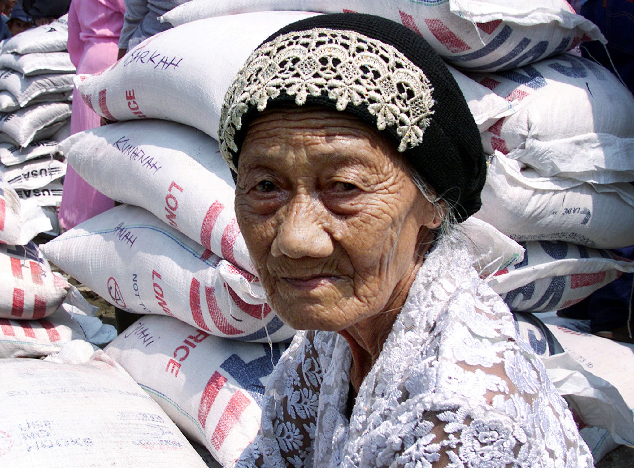 An elderly woman waits for rice to be distributed by the U.S. Agency for International Development (USAID) aid agency, in a North Jakarta, Indonesia, on September 4, 2001.