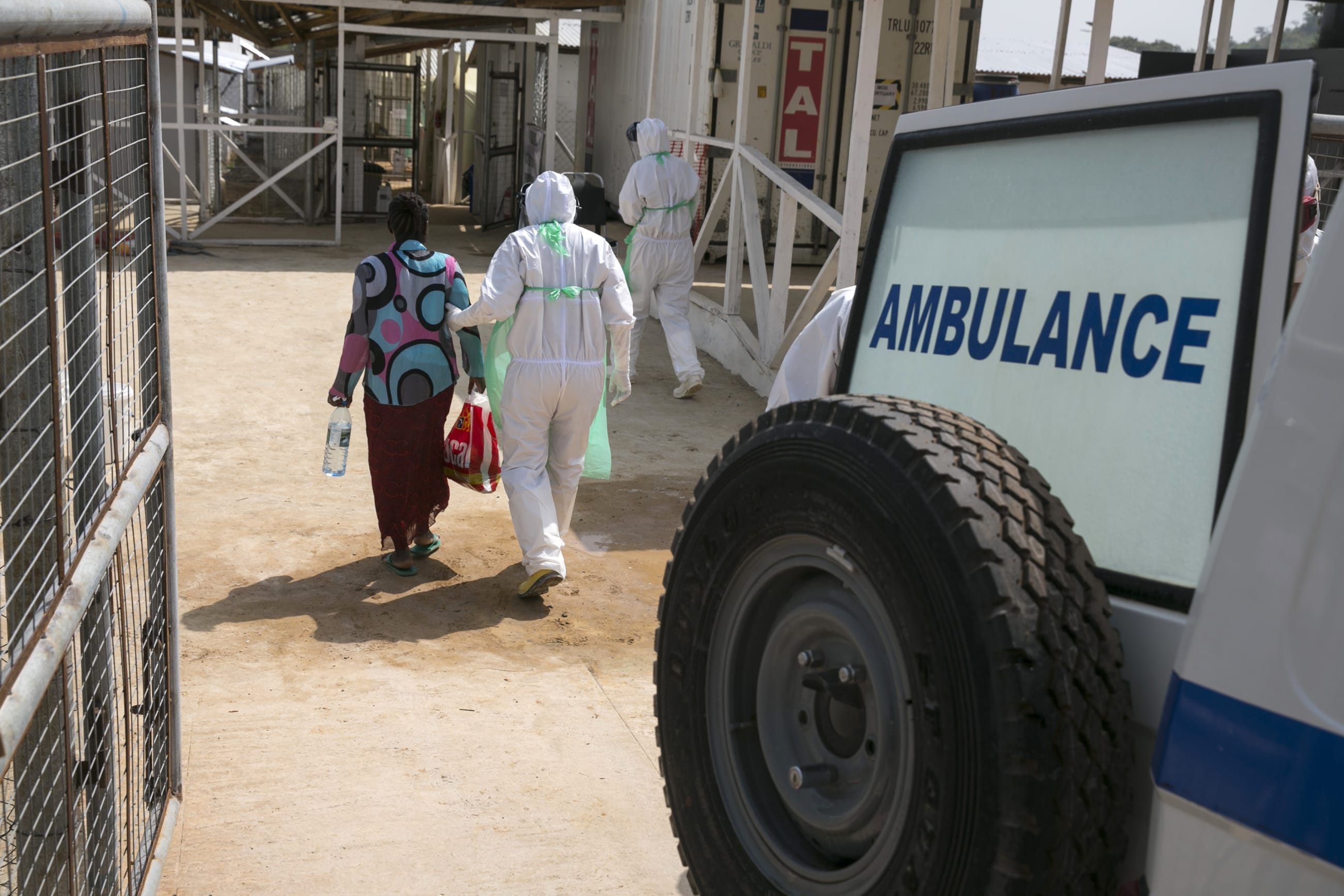 A health worker escorts a newly admitted Ebola patient into the Kerry Town Ebola treatment center, outside Freetown, Sierra Leone, on December 22, 2014.