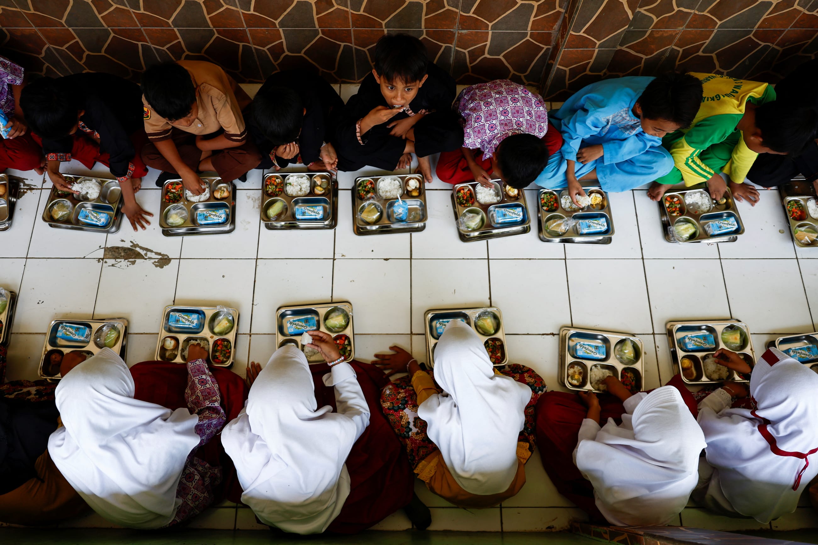 Students eat their meals from the free nutritious meals program trial during their break time at their school in Sukabumi, West Java province, Indonesia, September 26, 2024. REUTERS/Willy Kurniawan