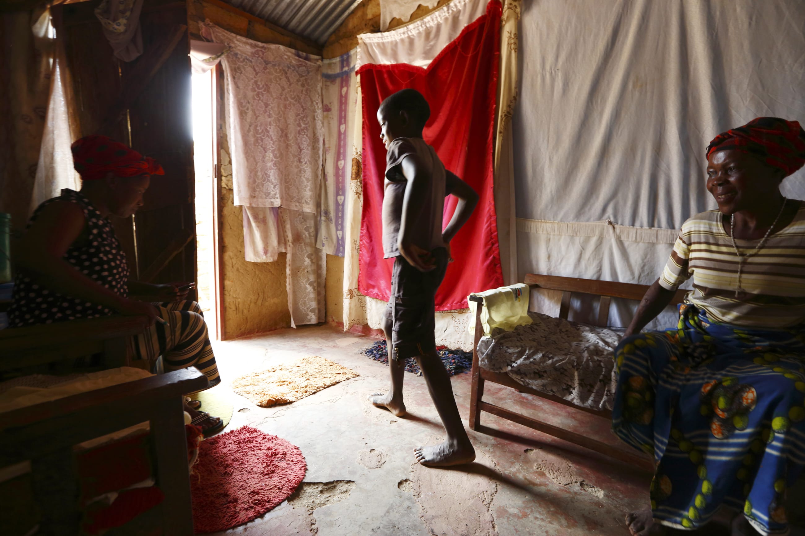 A 12-year-old boy living with HIV, leaves the room during a visit by home-based care coordinator with his mother, who is also HIV-positive, at their home in Chiyobola village, Zambia, on February 21, 2015.