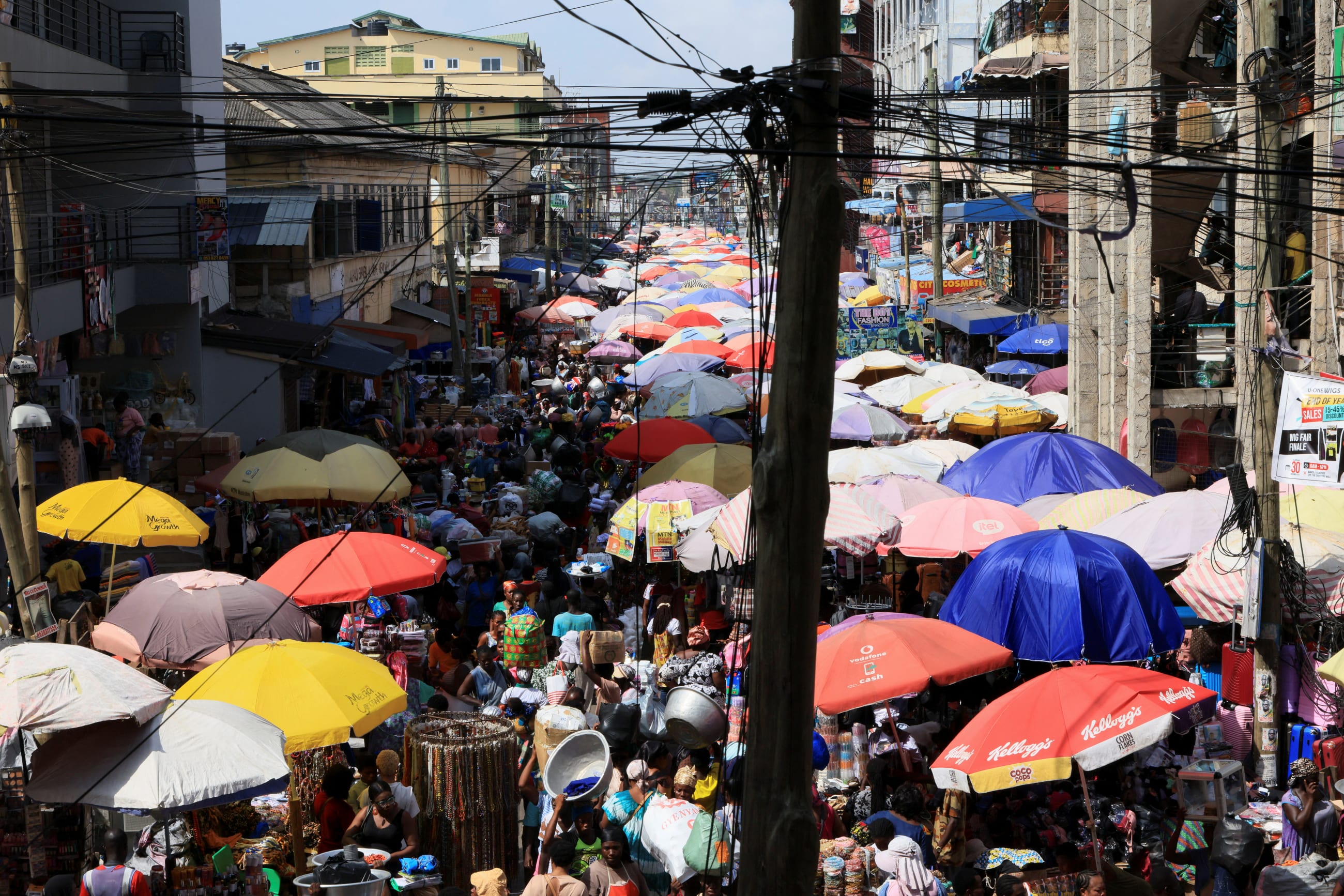 Stall umbrellas line sections of a busy street in Makola market, in Accra, Ghana, on December 6, 2025.
