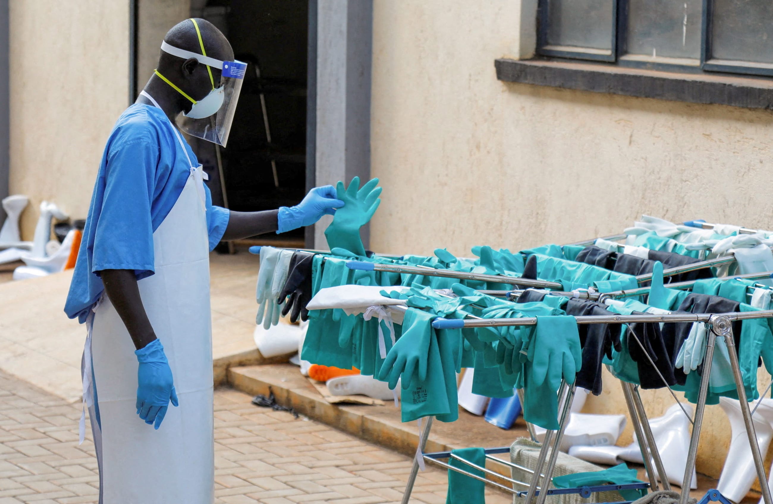 A Ugandan worker collects a rubber glove from the airing line at the Mulago National Referral Hospital Isolation Unit, in Kampala, Uganda, on June 8, 2026.