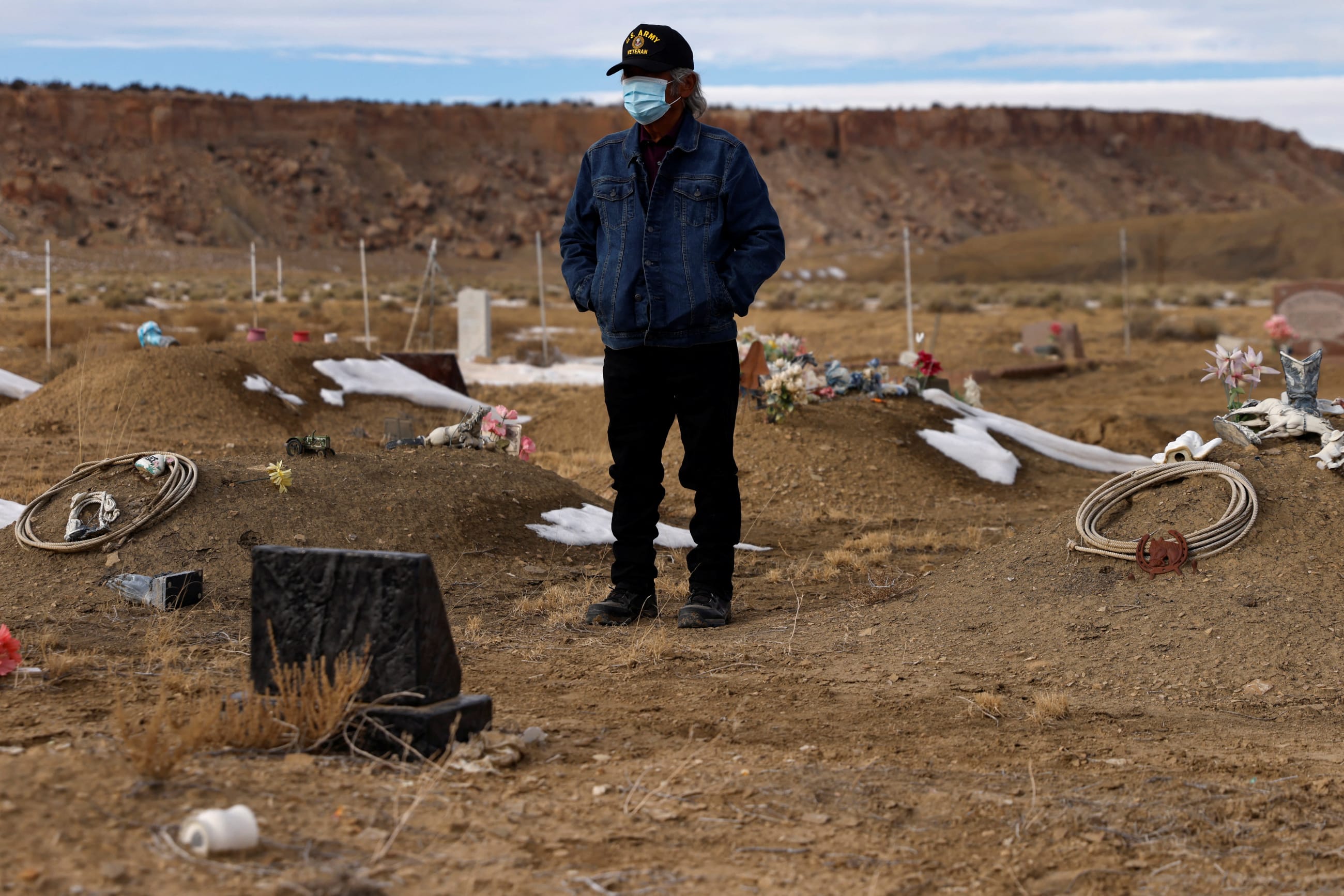 Wallace Buck stands alone waiting for the burial of his sons, who both died from complications of COVID-19, at the family plot on the Sanostee chapter of the Navajo nation, in Sanostee, New Mexico, on December 16, 2021