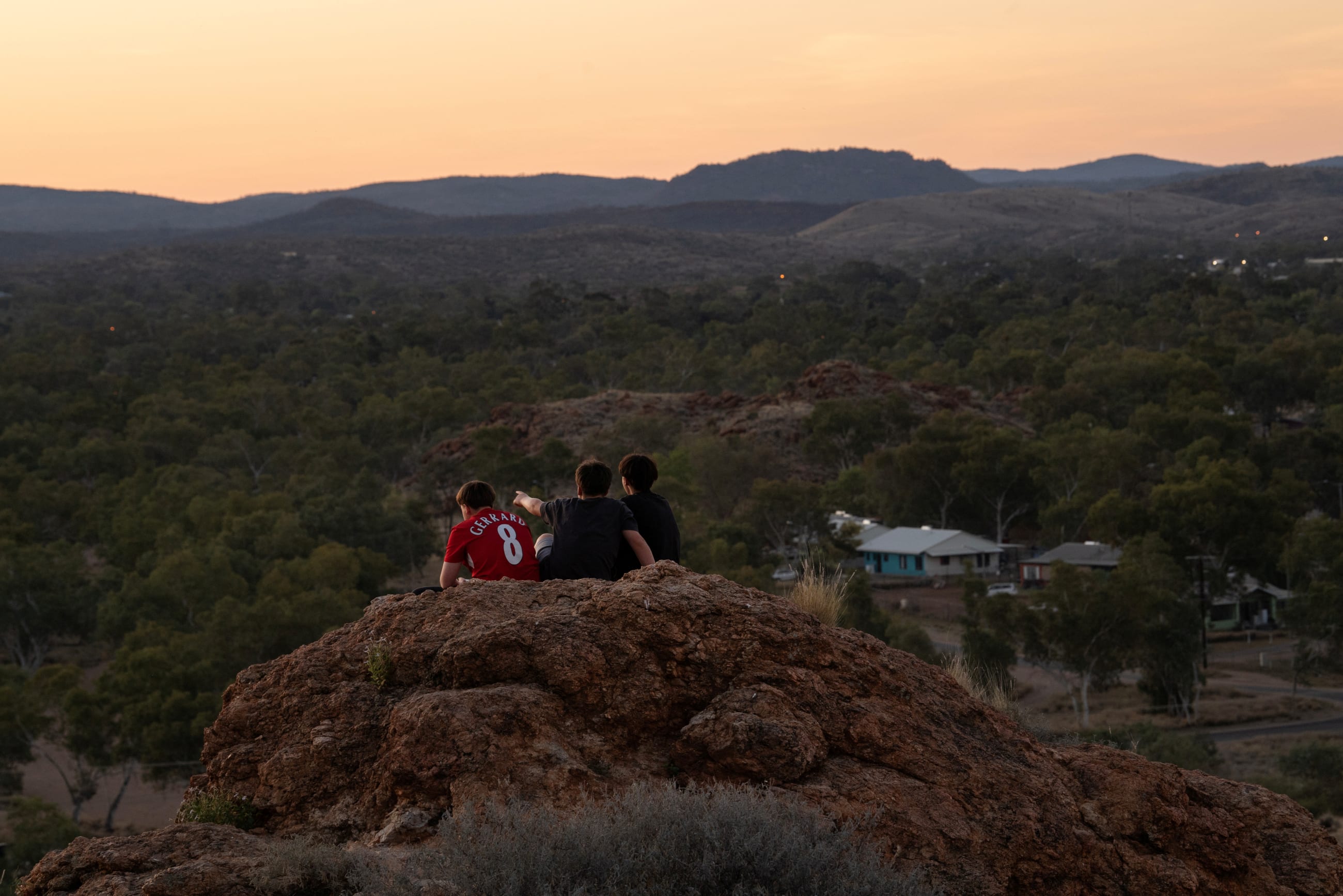 Boys watch the sunset, ahead of a nationwide referendum on Indigenous issues, over the township of Alice Springs, Australia, on September 14 2023.