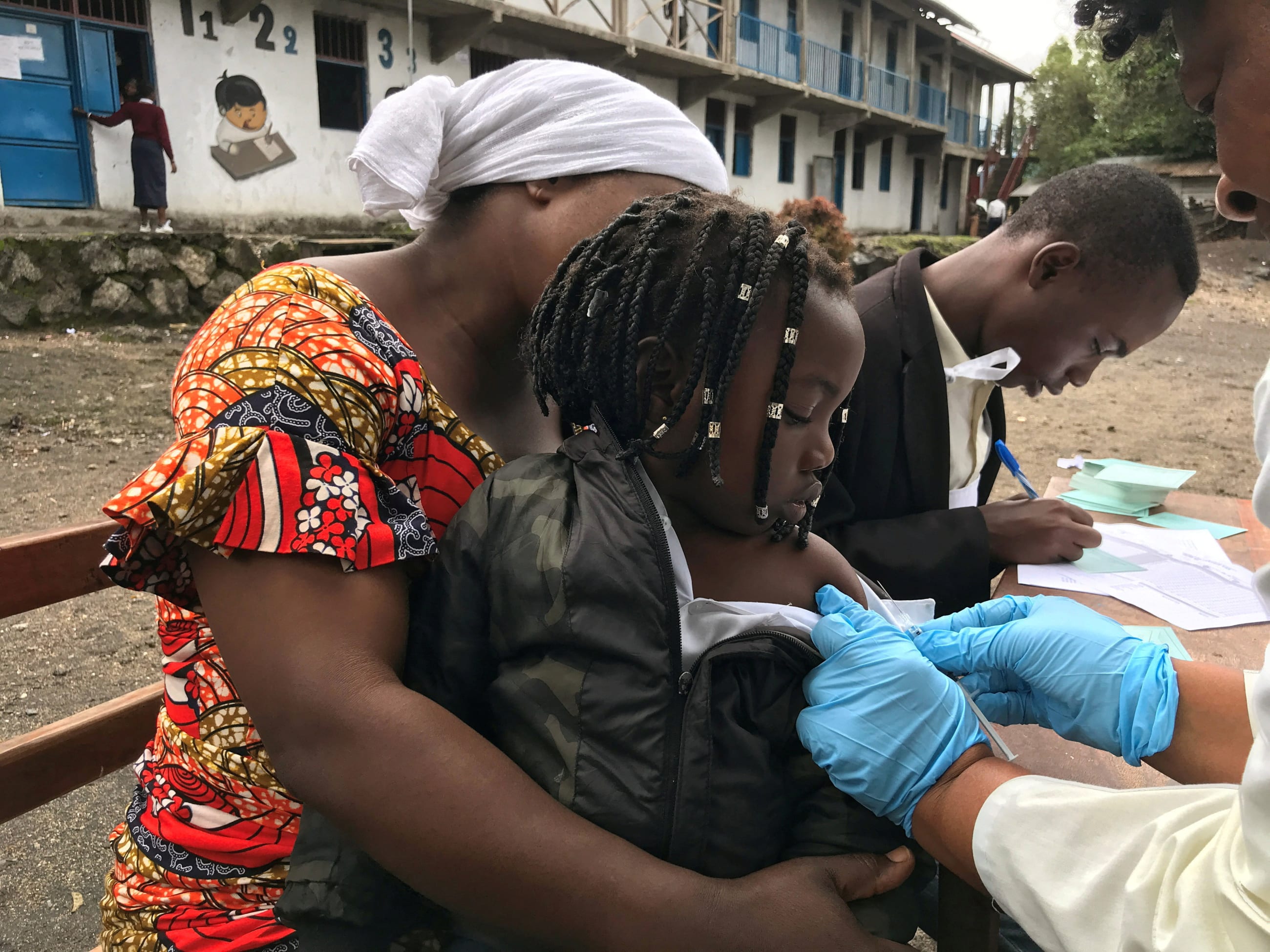 Health workers vaccinate a girl against measles at a school in Goma, Democratic Republic of Congo, on December 11, 2019.