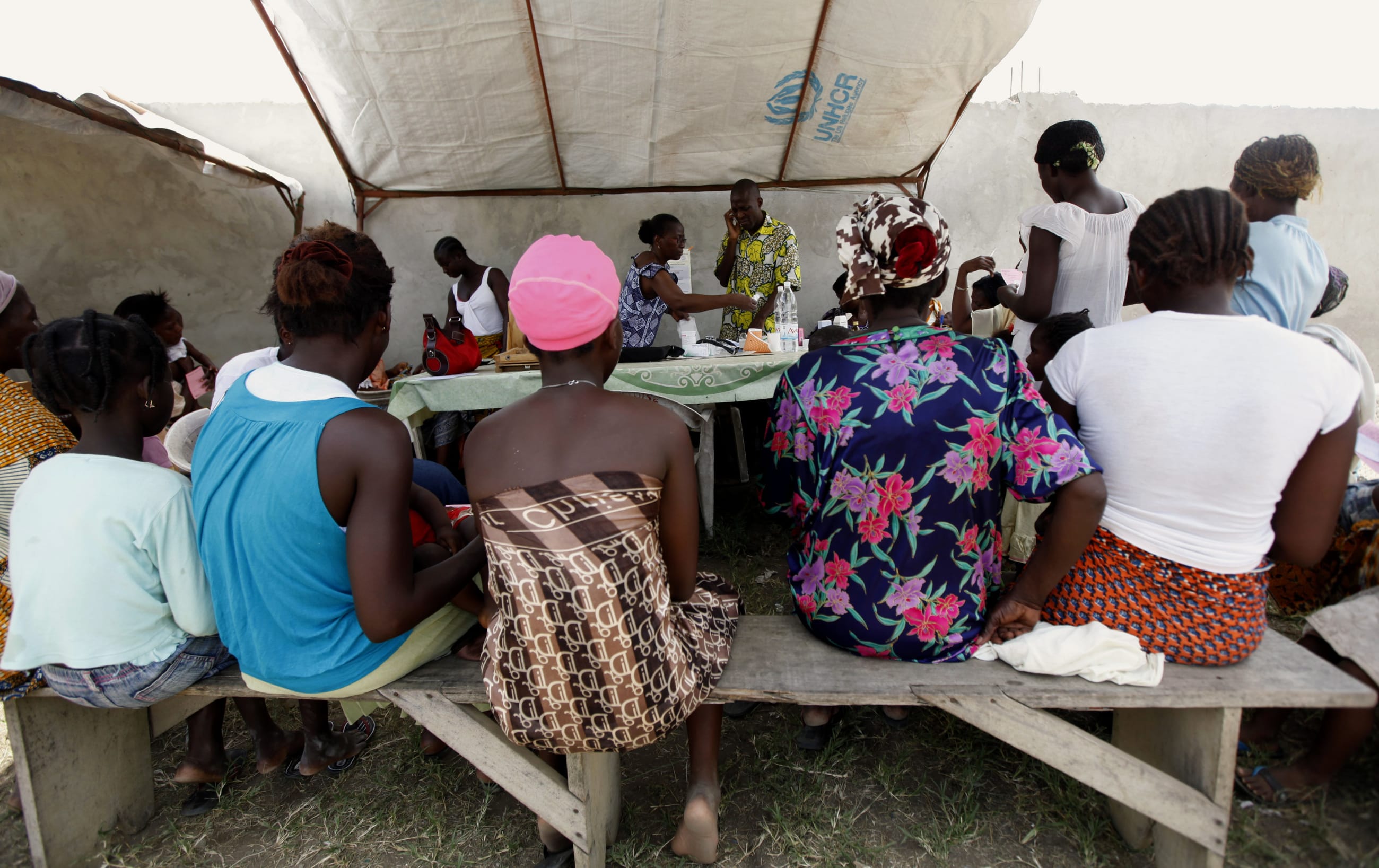 Women wait for vaccinations by a team from UNICEF, at St. Ambrose church, in Angree, Abidjan, Ivory Coast, on March 9, 2011.