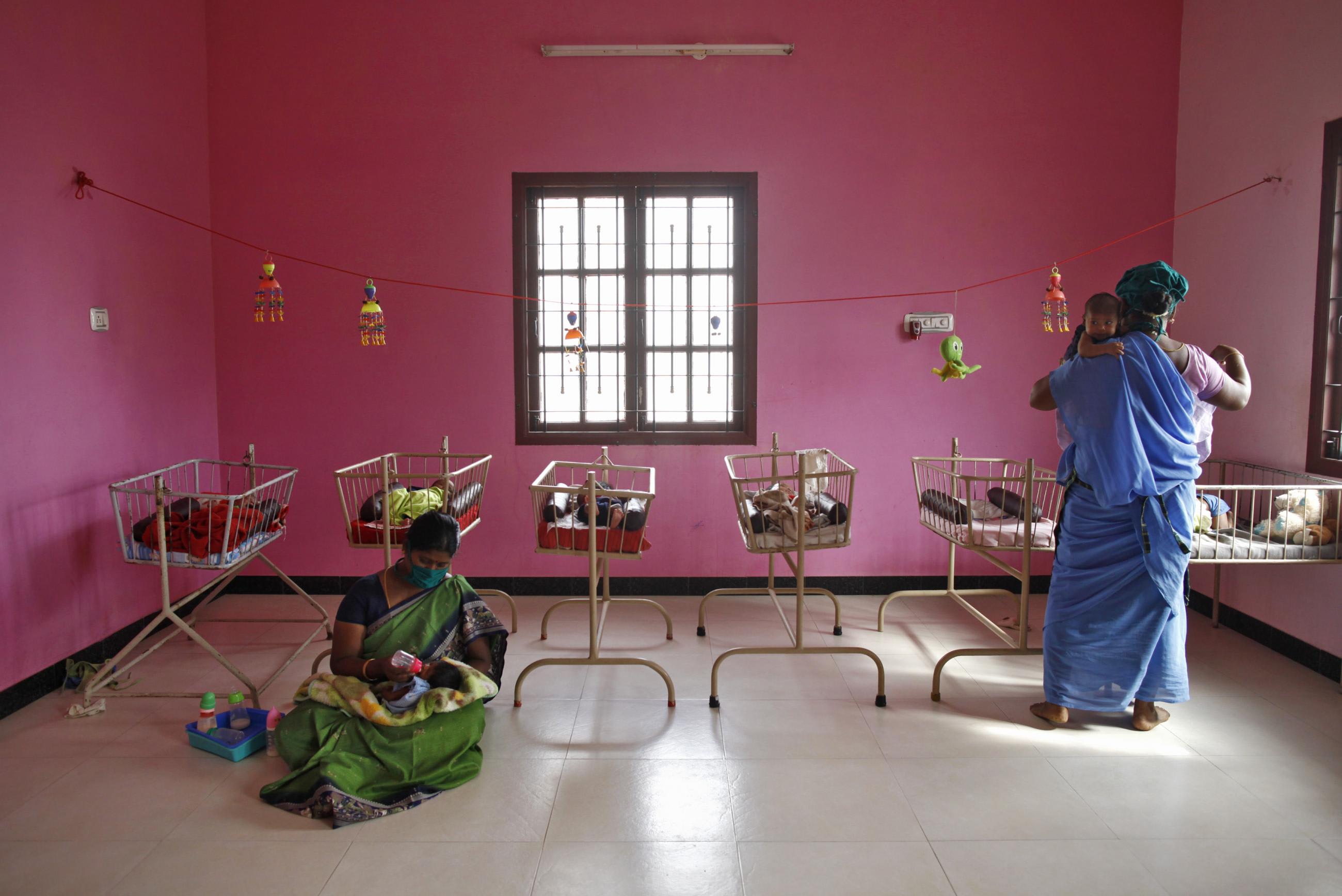 Nurses tend to newborn baby girls at the Life Line Trust orphanage in Salem in the southern Indian state of Tamil Nadu June 20, 2013. These unwanted infant girls in southern India's Tamil Nadu state are considered the fortunate ones. They are India's "Cradle Babies," products of a government scheme that permits parents to give their unwanted baby girls anonymously to the state, saving them from possible death in a region where daughters are seen as a burden and where their murder is a common reality.