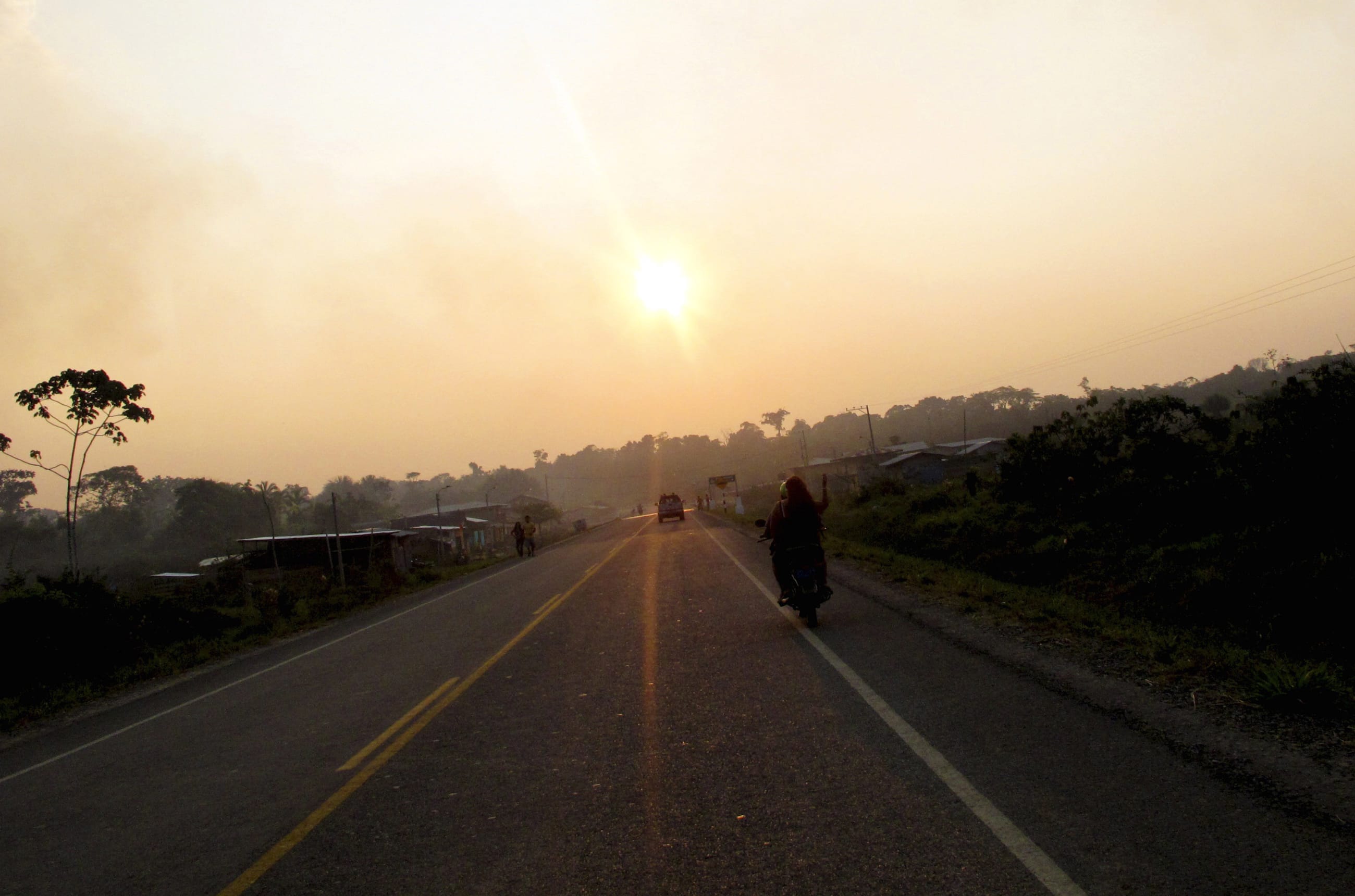 People ride a motorcycle along the Interoceanic highway section linking Peru and Brazil, in the Amazon region of Madre de Dios, on August 19, 2010.