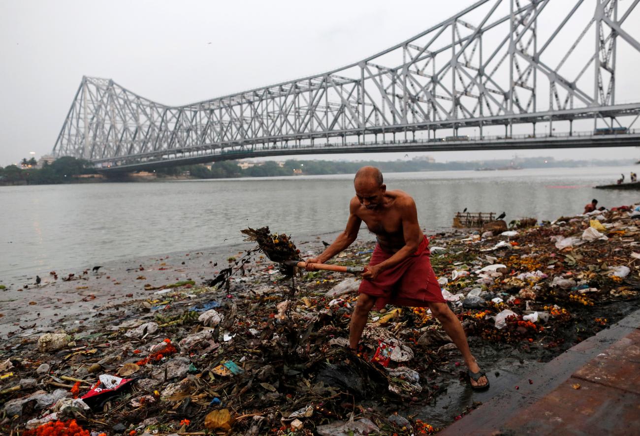 A man cleans garbage along the banks of the Ganges River, in Kolkata, India, on April 9, 2017.