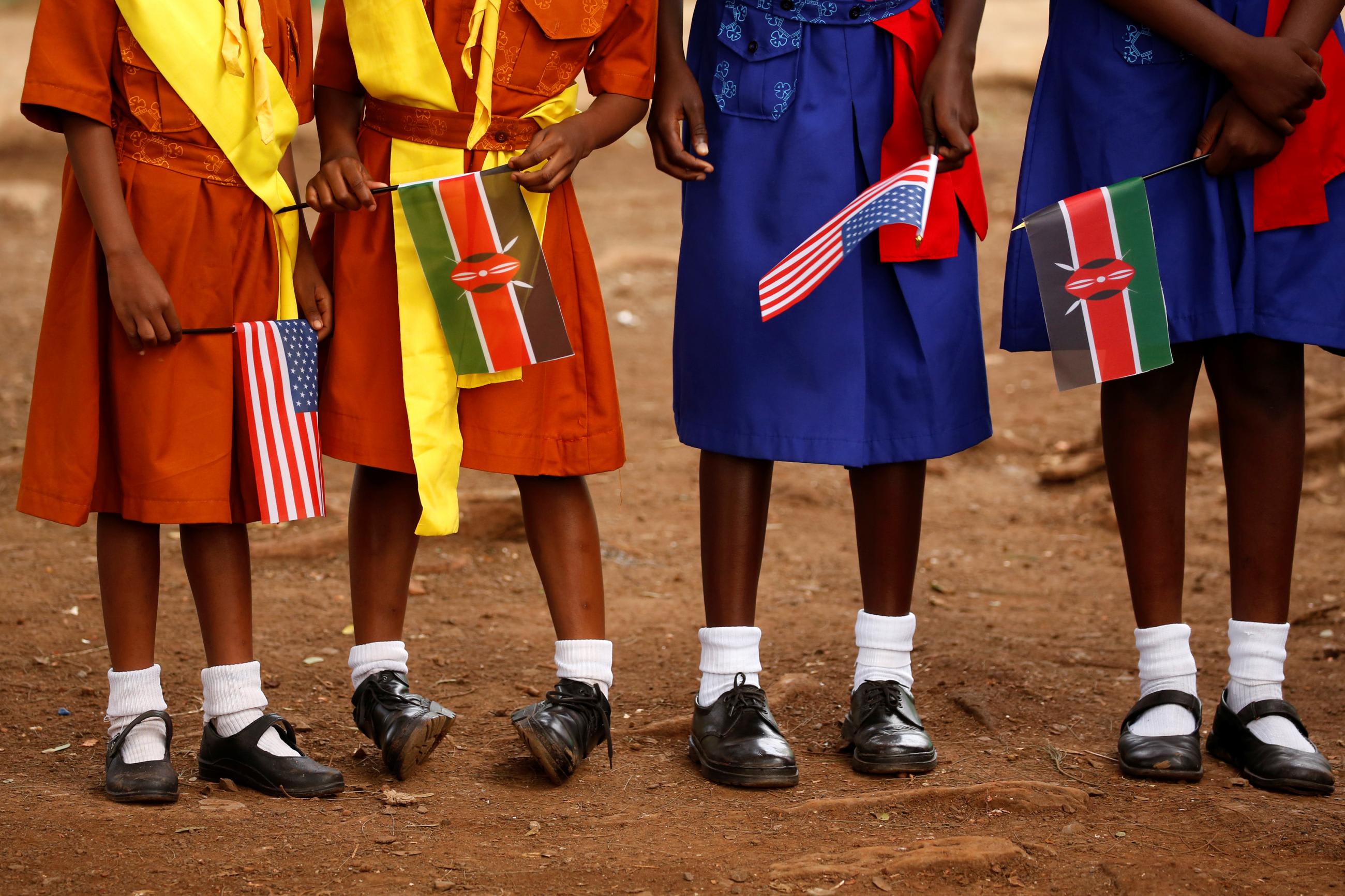 Young girls with U.S. and Kenya flags wait to greet U.S. Ambassador to Kenya Robert Godec as he visits a President's Emergency Plan for AIDS Relief (PEPFAR) project for girls' empowerment in Nairobi, Kenya, March 10, 2018.