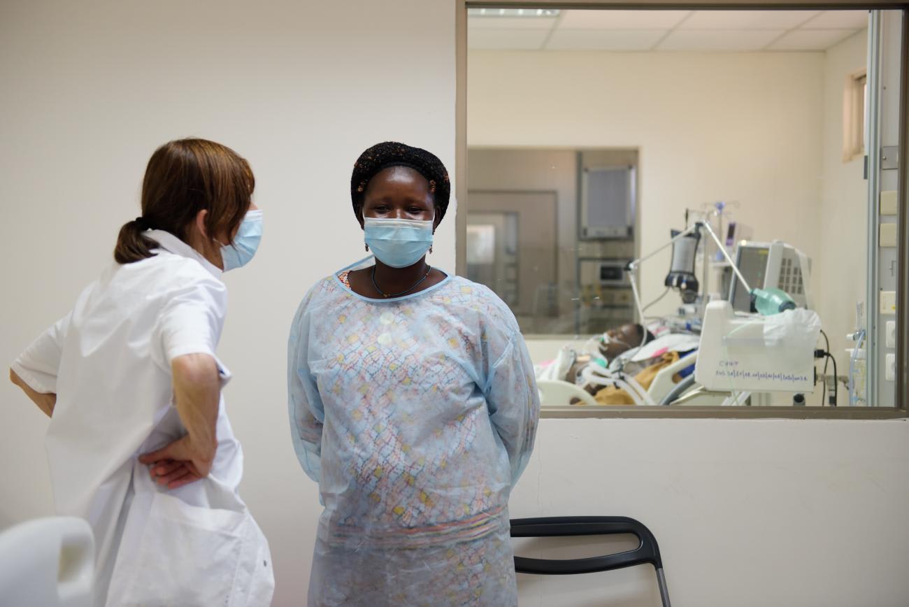 A medical volunteer of the French medical association "La Chaine de l'Espoir" comforts a patient's mother at the General Hospital Tengandogo in Ouagadougou, Burkina Faso on January 14, 2021.