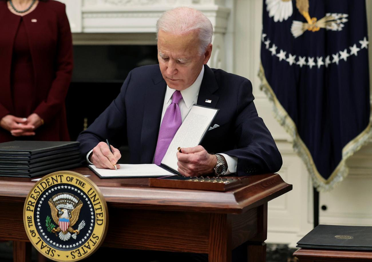 President Joe Biden signs an executive order reversing the U.S. decision to withdraw from the WHO as part of his administration's plans to fight the coronavirus disease pandemic during a COVID-19 response event at the White House in Washington, DC on January 21, 2021.