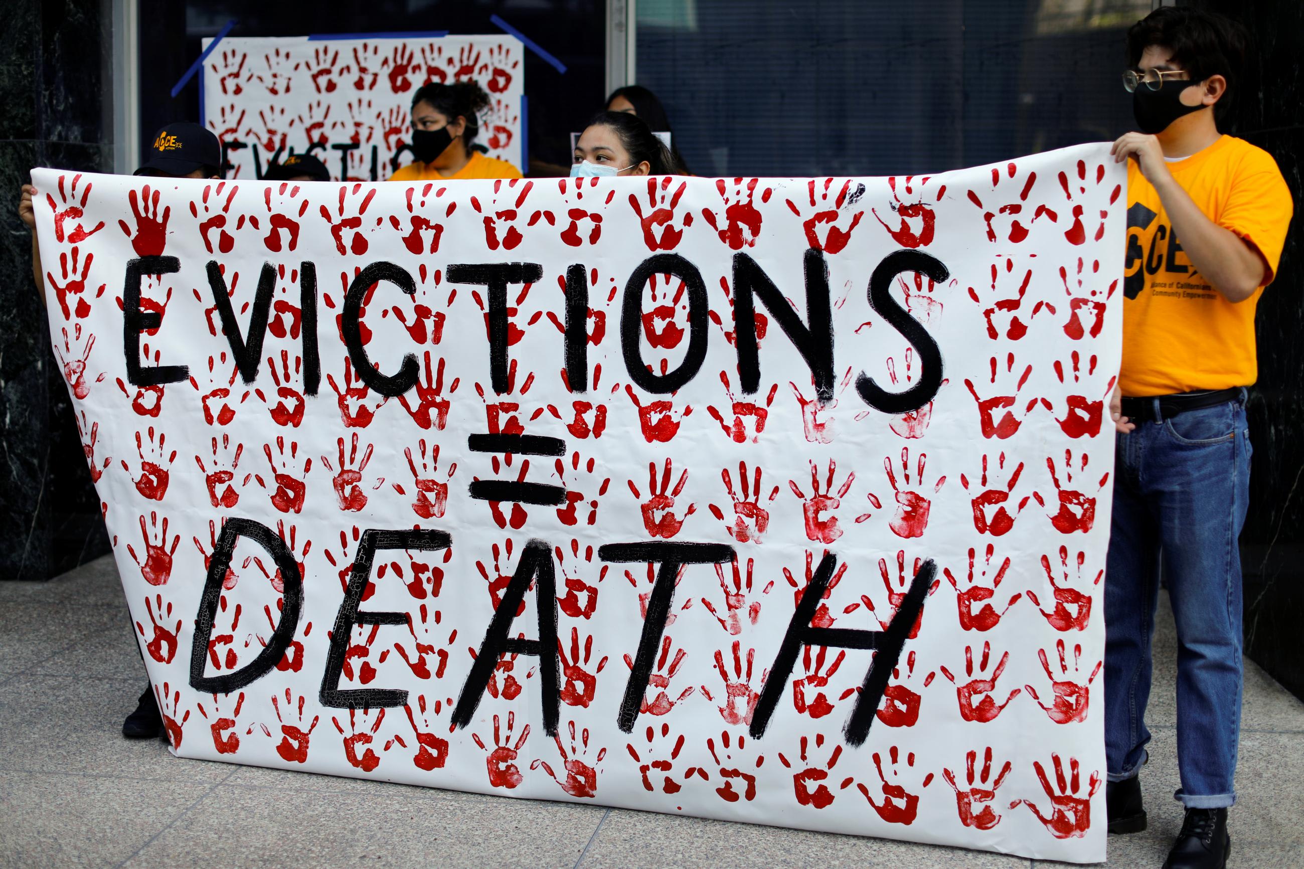 Renters hold up signs as they protest to promote a State government bill that will prohibit landlords from evicting tenants because of unpaid rent due to the outbreak of the coronavirus disease in San Diego, California on July 17, 2020.