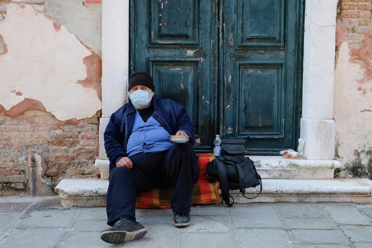 A homeless man wearing a protective mask is seen in Venice as the Italian government allows the reopening of some shops while a nationwide lockdown continues following the outbreak of the coronavirus disease (COVID-19), in Venice, Italy, April 14, 2020.